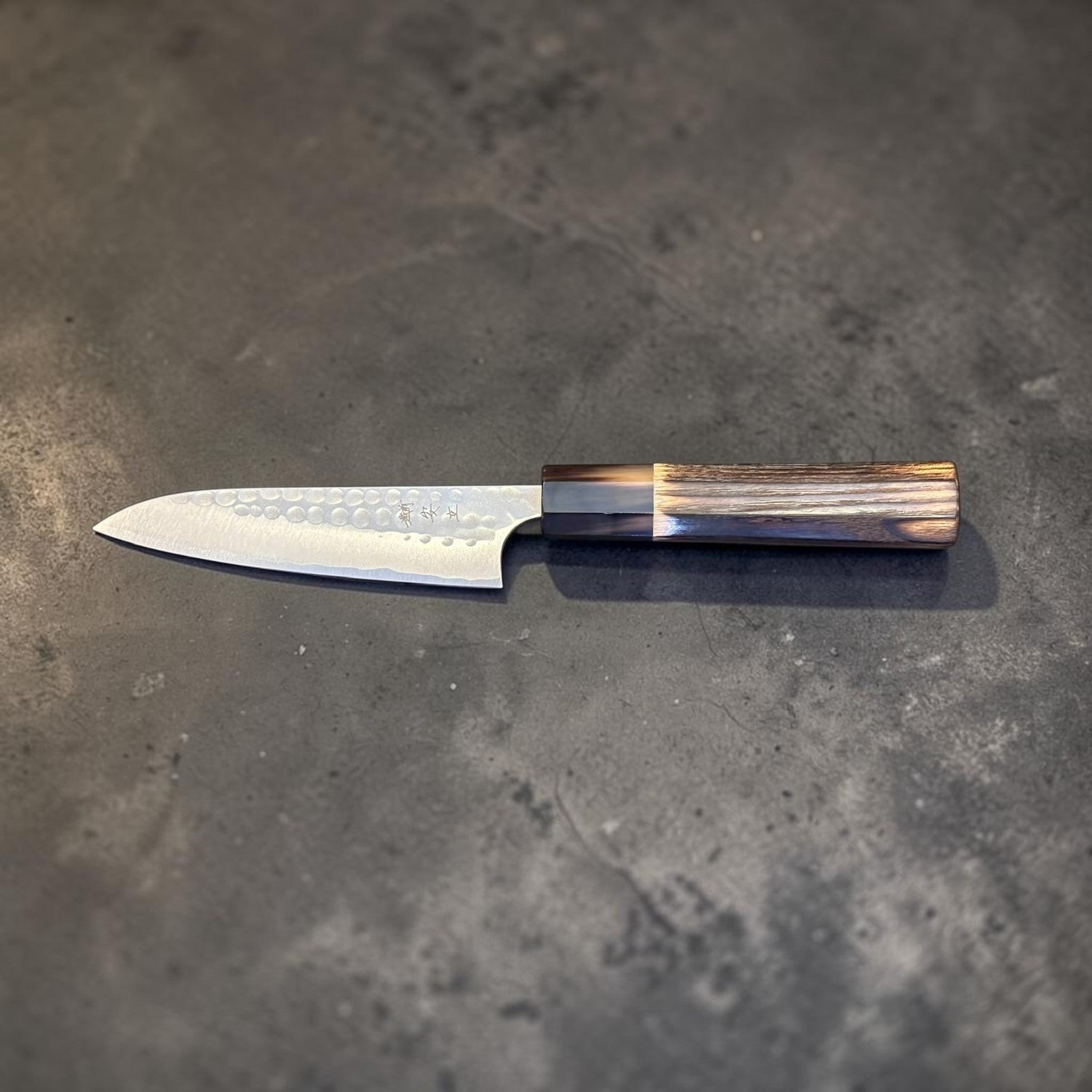 Anryu Aogami #2 Tsuchime Petty 120 mm with burnt wood handle and black buffalo horn ferrule, reverse full profile view showing burnt wood handle and black buffalo horn ferrule.