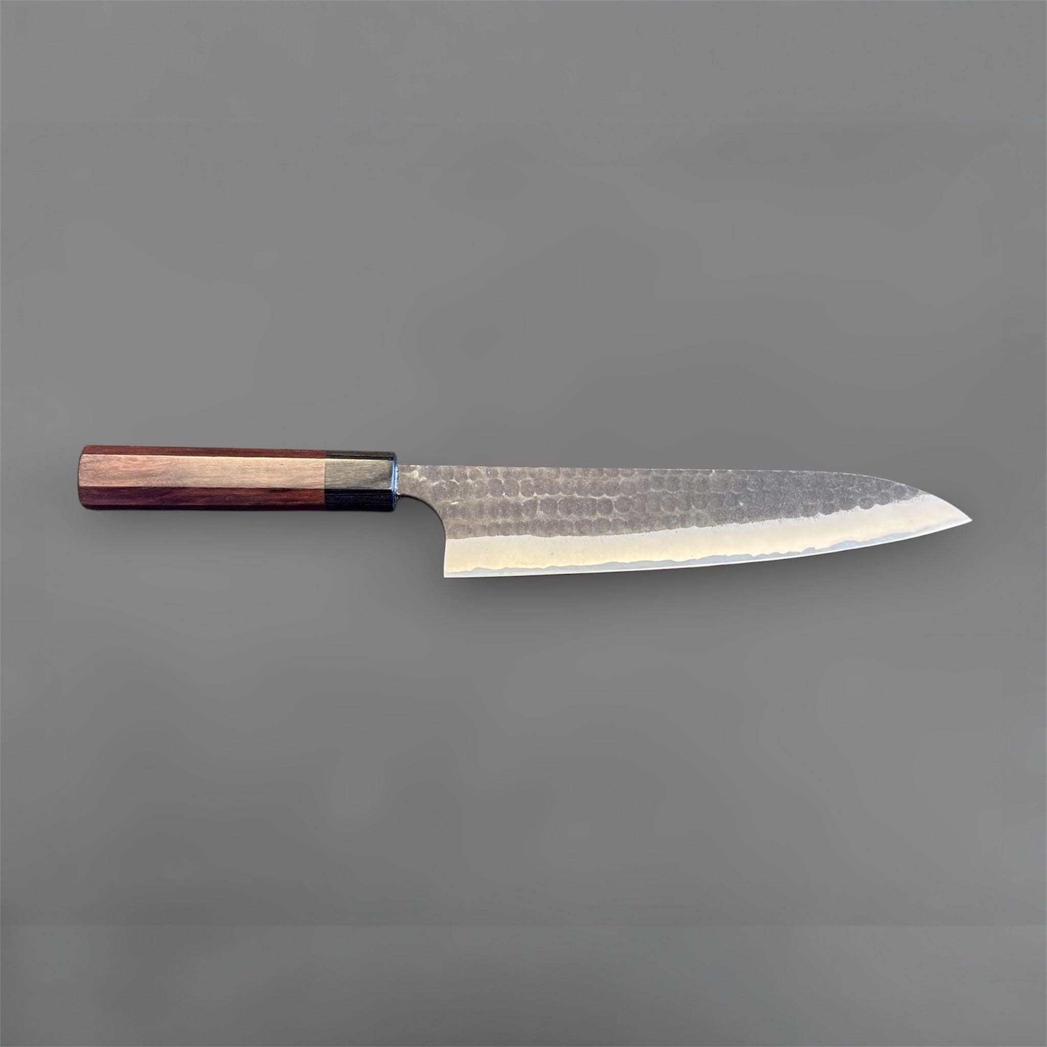 Anryu Aogami Super Kurouchi Gyuto 210 mm, full profile from reverse side showing the long gyuto shape, kurouchi tsuchime finish, and purple-toned handle.