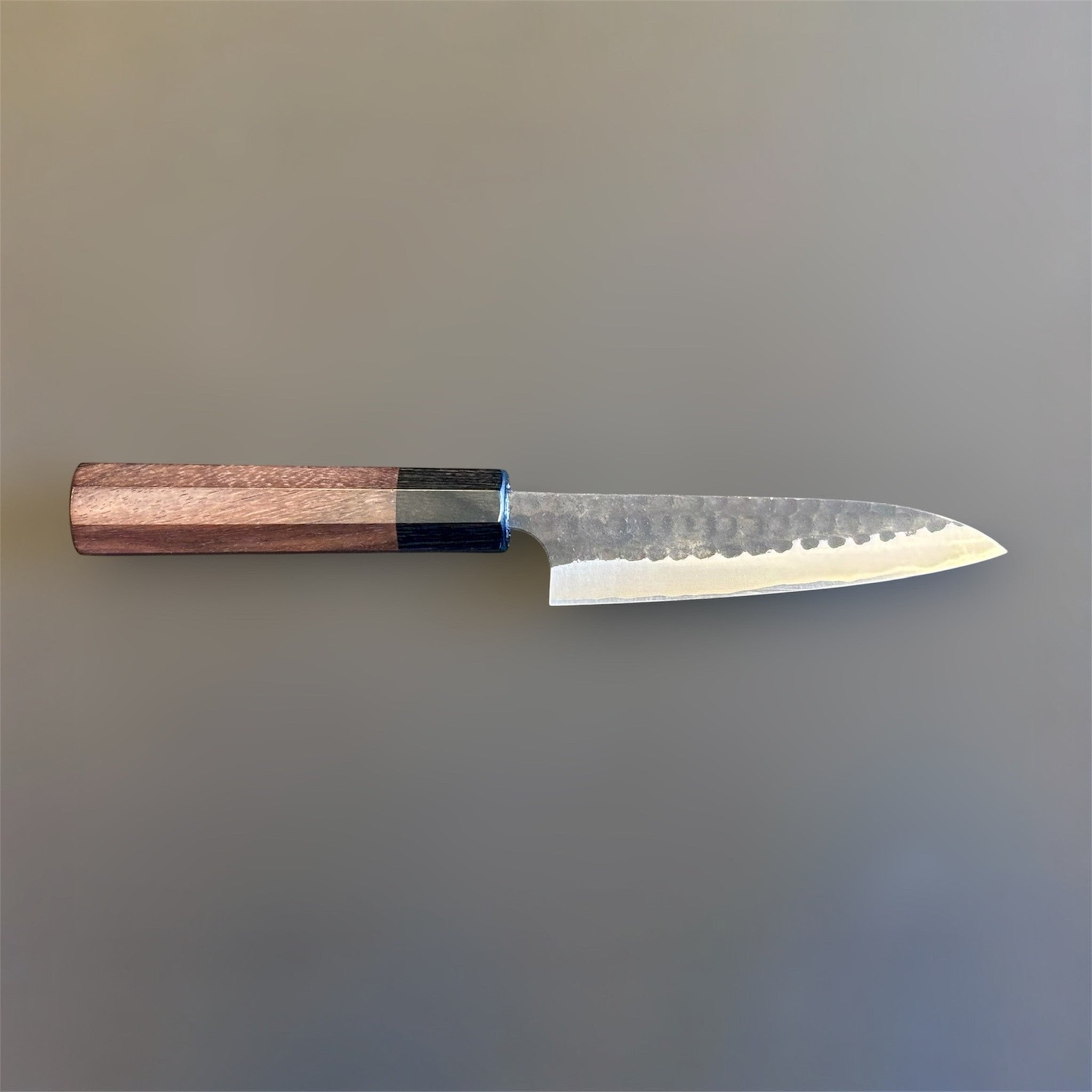 Anryu Aogami Super Kuro Tsuchime Petty 120 mm with rosewood octagon handle, full profile view showing the hammered kurouchi finish and compact utility blade.