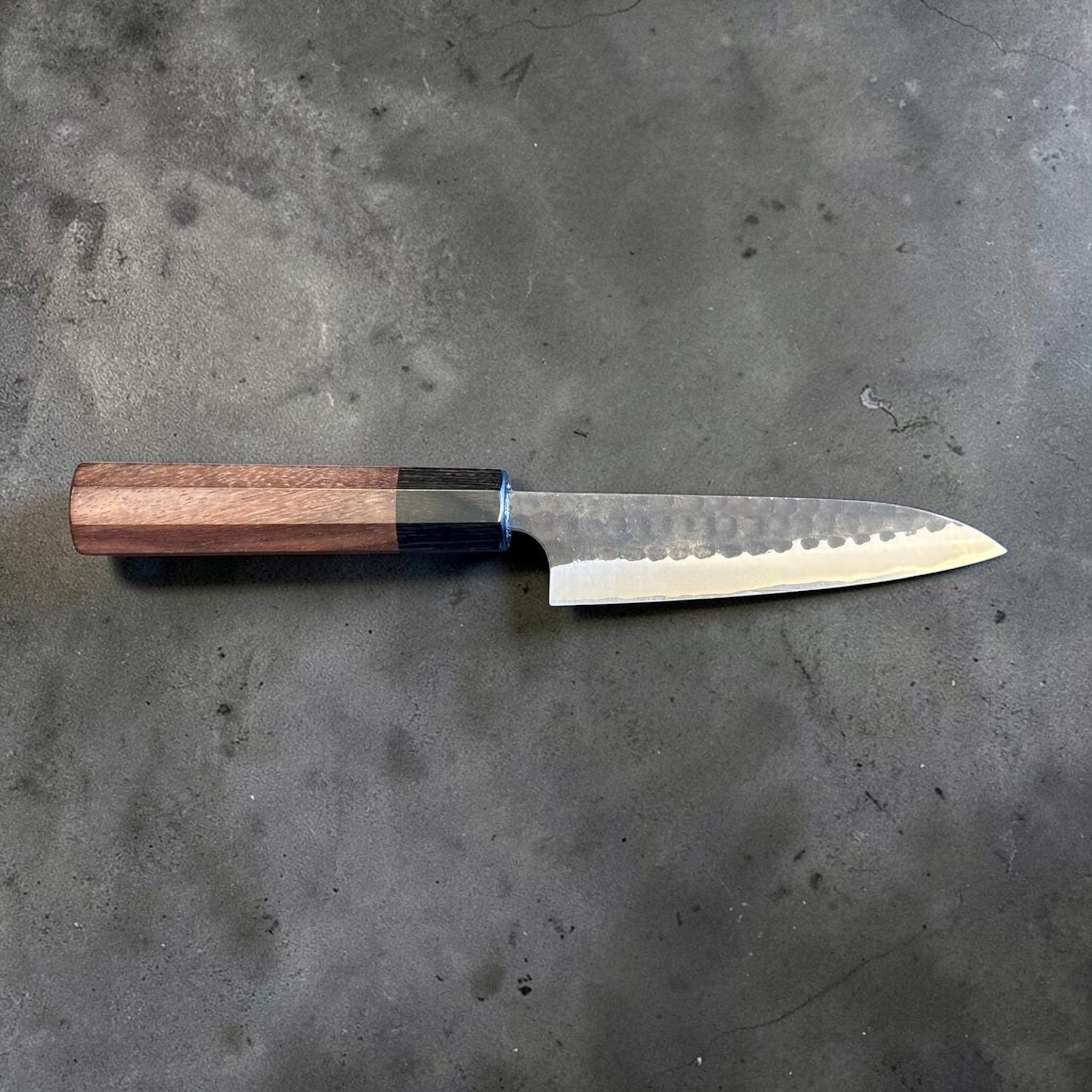Anryu Aogami Super Kuro Tsuchime Petty 120 mm with rosewood octagon handle, full profile view showing the hammered kurouchi finish and compact utility blade.