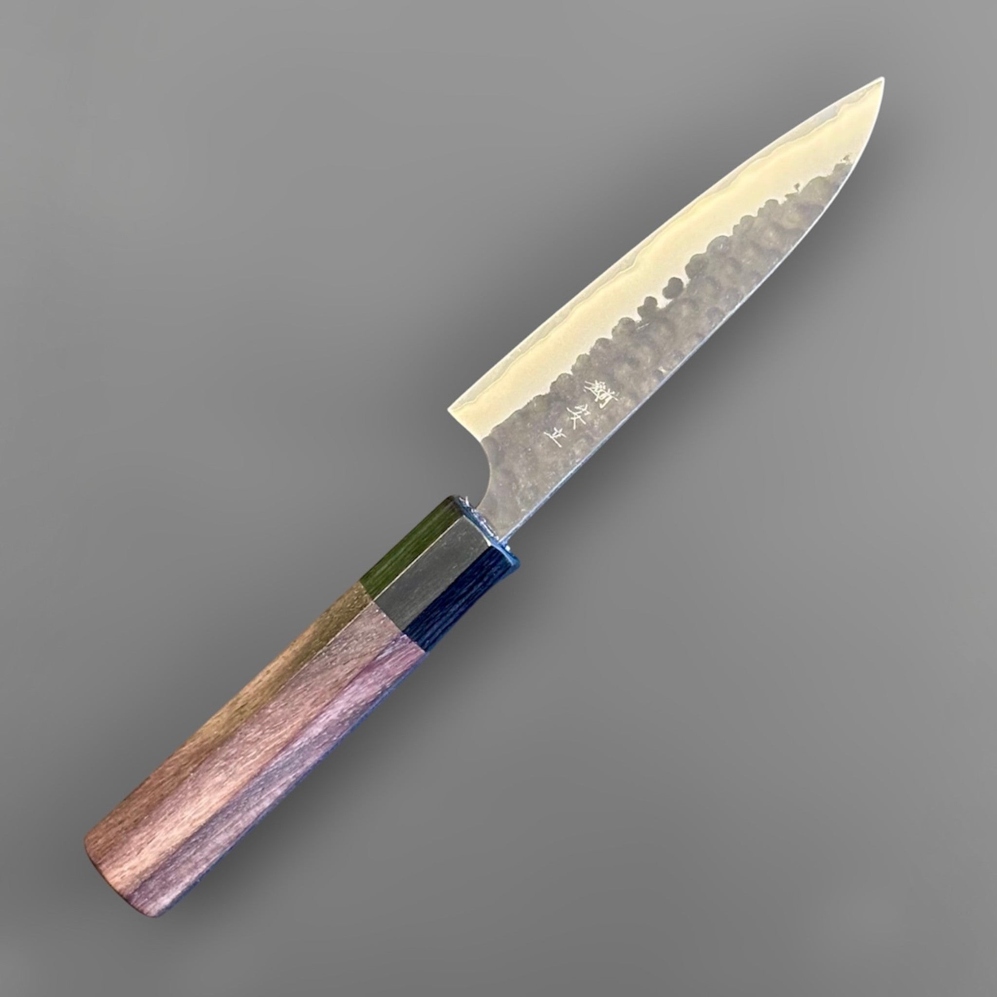 Anryu Aogami Super Kuro Tsuchime Petty 120 mm with rosewood octagon handle, opposite angled view showing the slim pointed tip and handcrafted handle geometry.