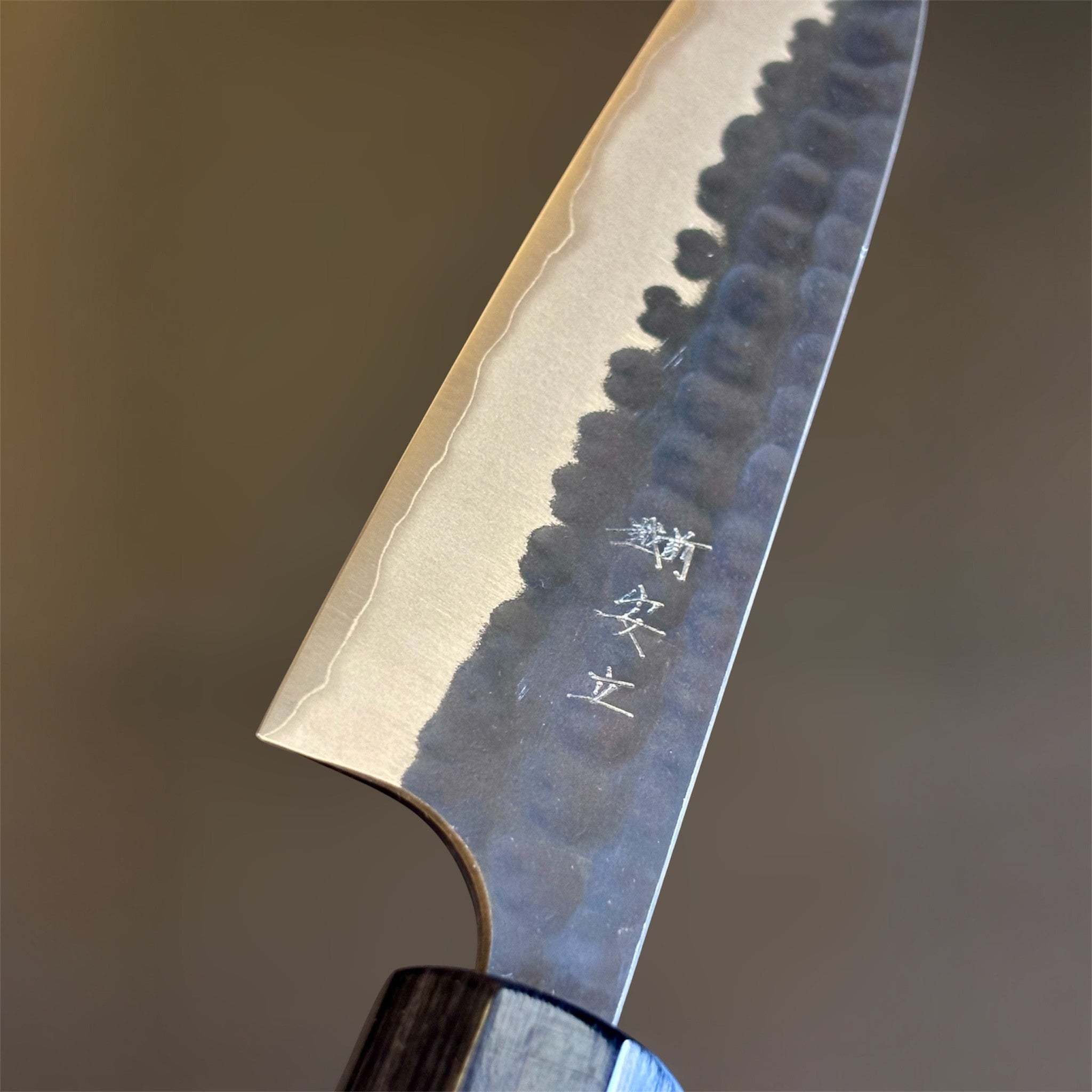 Anryu Aogami Super Kuro Tsuchime Petty 120 mm, close-up of the blade face with engraved kanji, misty kasumi edge line, and hammered kurouchi texture.