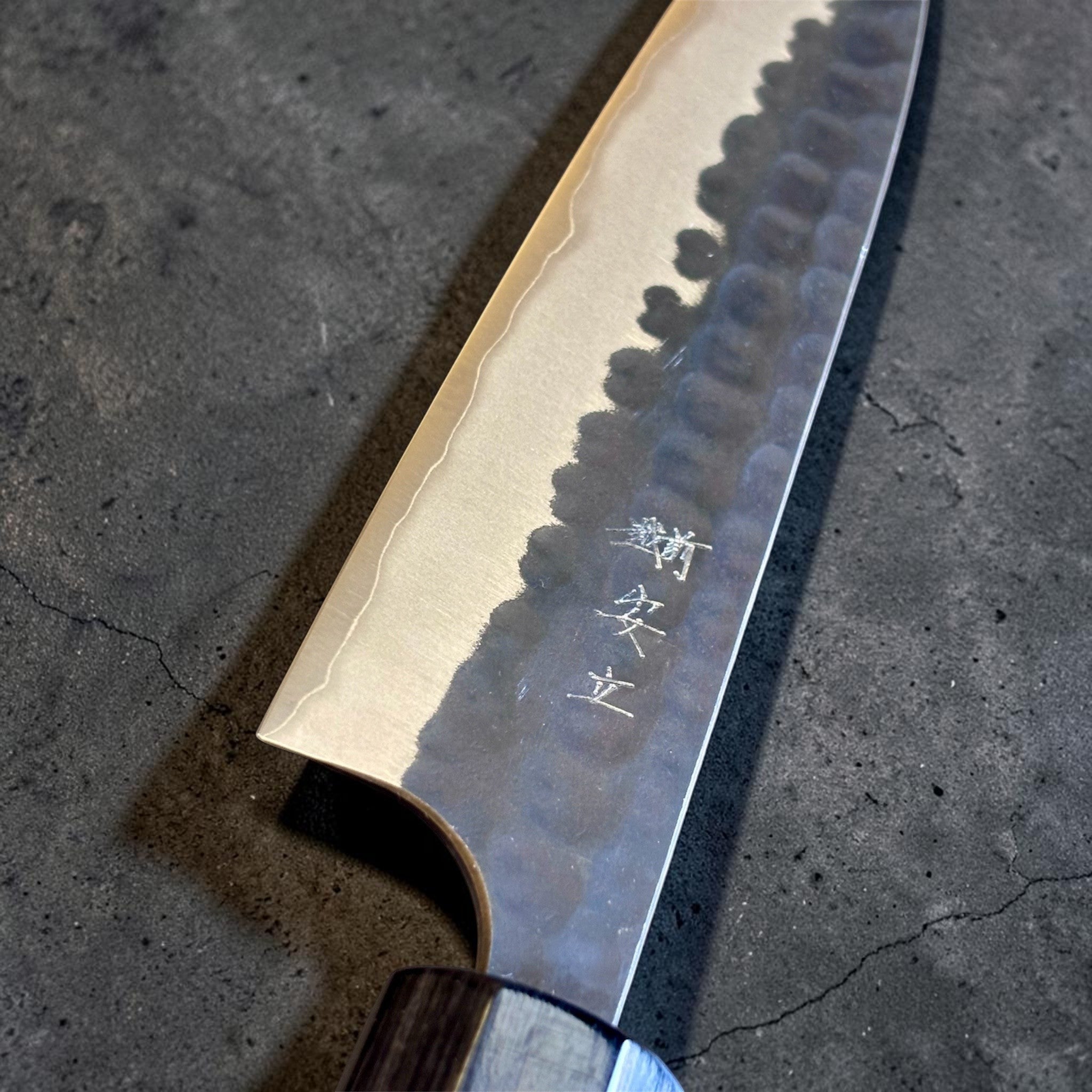 Anryu Aogami Super Kuro Tsuchime Petty 120 mm, close-up of the blade face with engraved kanji, misty kasumi edge line, and hammered kurouchi texture.