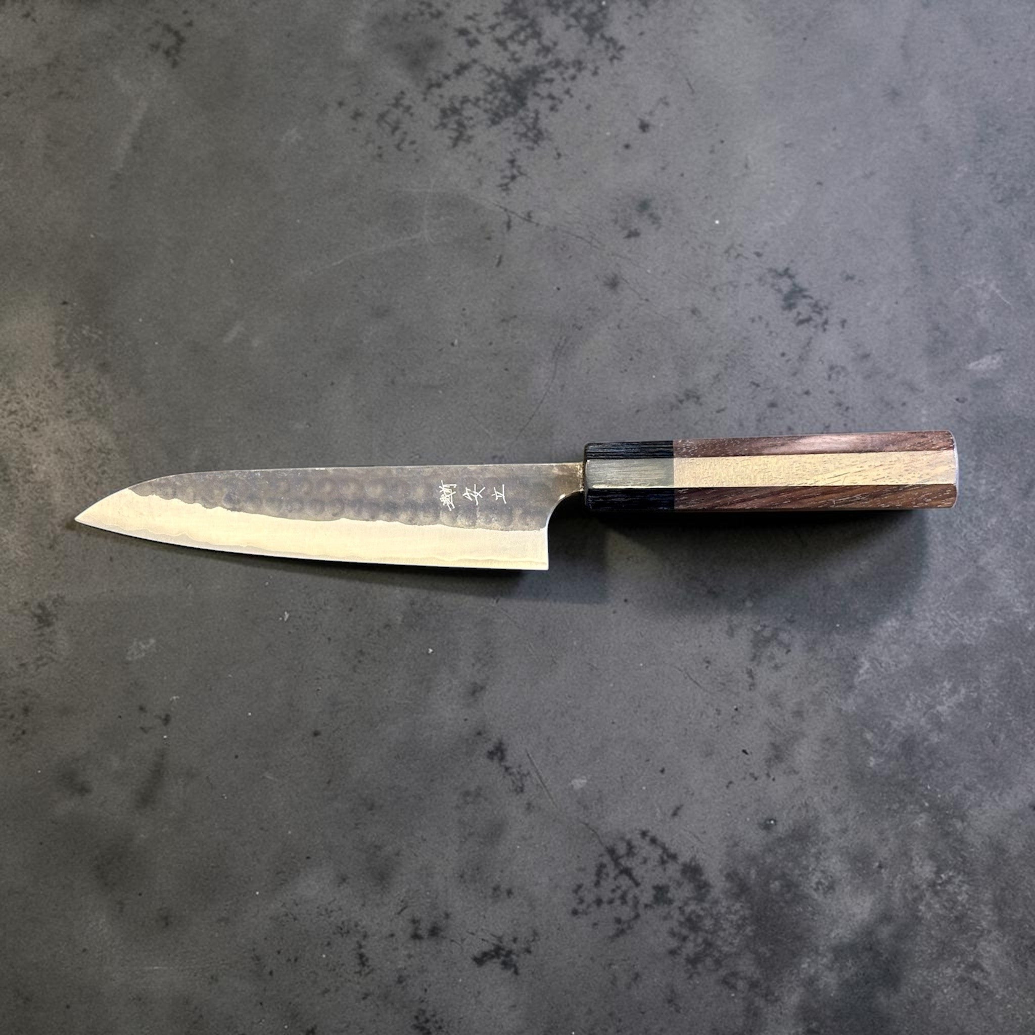 Anryu Aogami Super Kuro Tsuchime Petty 150 mm with rosewood octagon handle, full profile view showing the hammered kurouchi finish and longer petty blade.