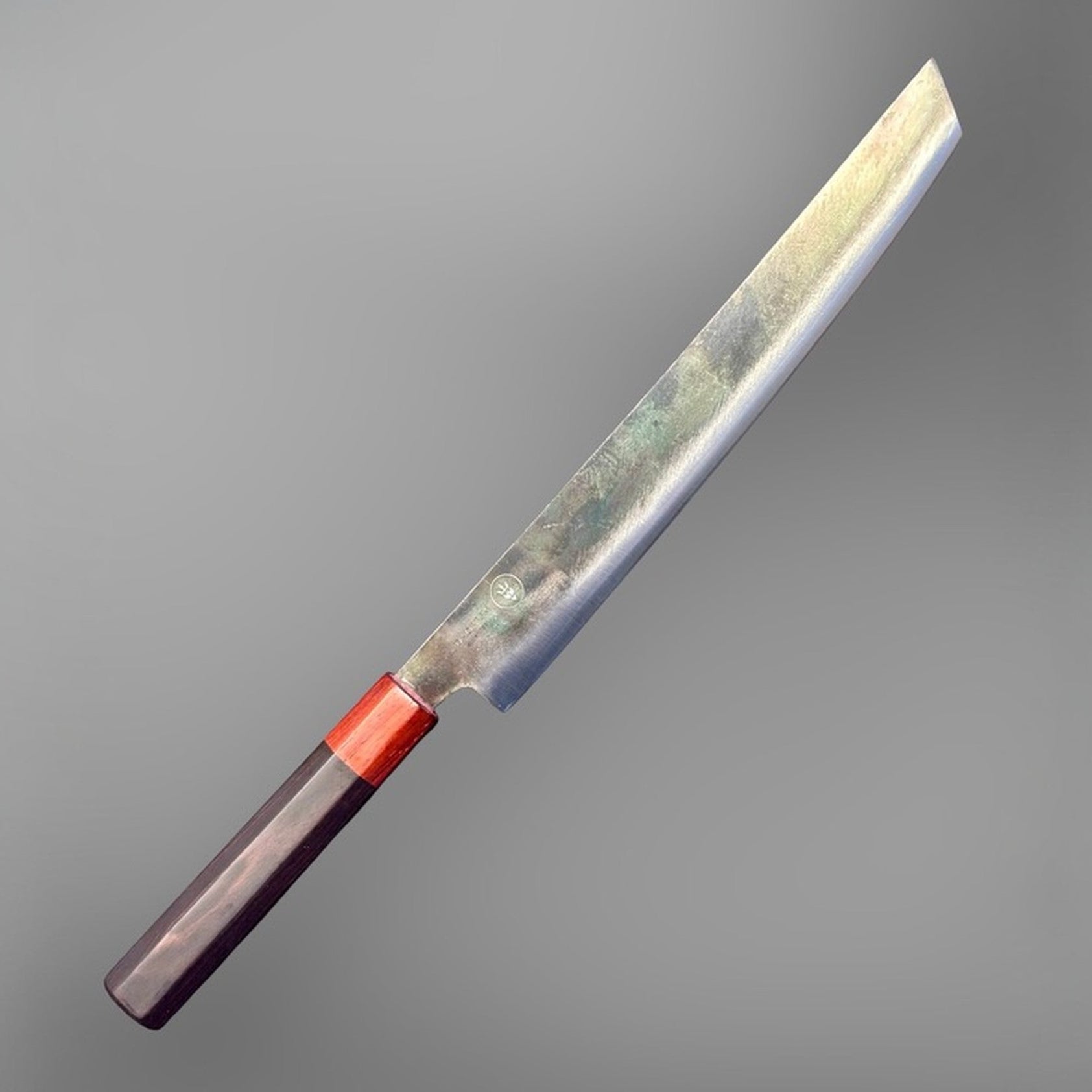 Dao Vua V3 52100 carbon steel 270 mm sakimaru sujihiki slicer, angled right-side product view showing maker's mark and polished blade finish.