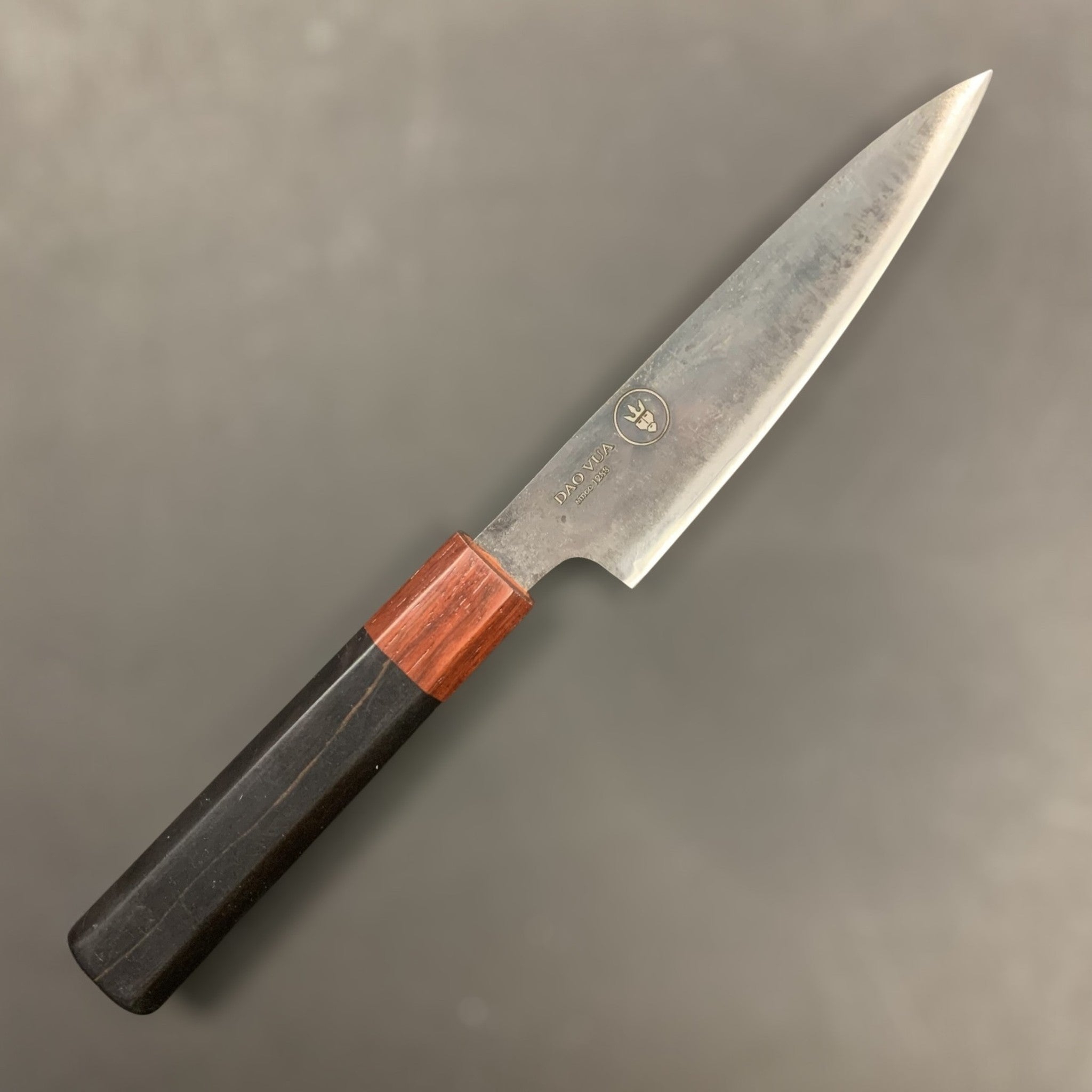 Dao Vua V3 52100 carbon steel 120 mm steak knife, right-side view showing octagonal two-tone wa handle against a grey background.
