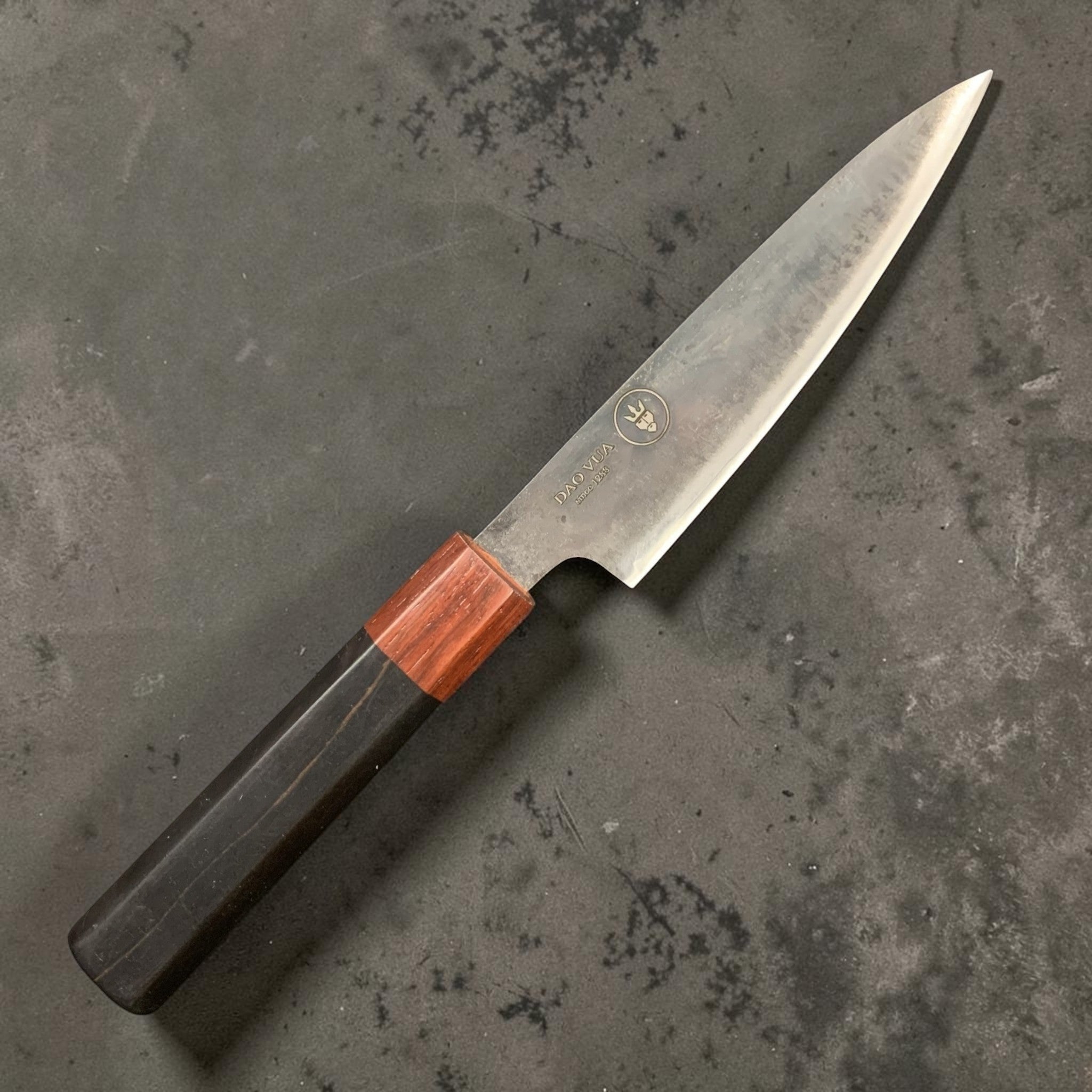 Dao Vua V3 52100 carbon steel 120 mm steak knife, right-side view showing octagonal two-tone wa handle against a grey background.