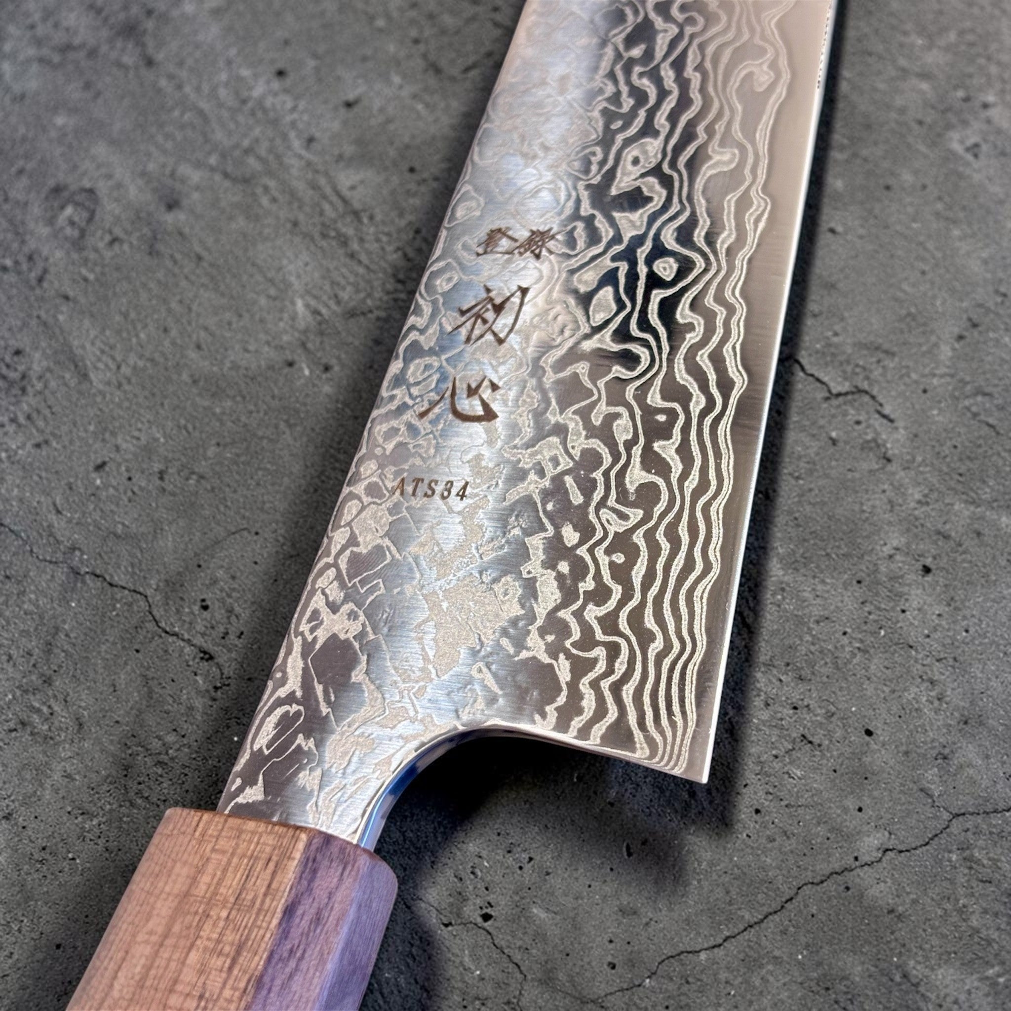 Hatsukokoro Ginga ATS-34 Nickel Damascus Gyuto 210 mm with Sanjo walnut handle and maple stripe, close-up of the blade heel, engraving, and Damascus detail.