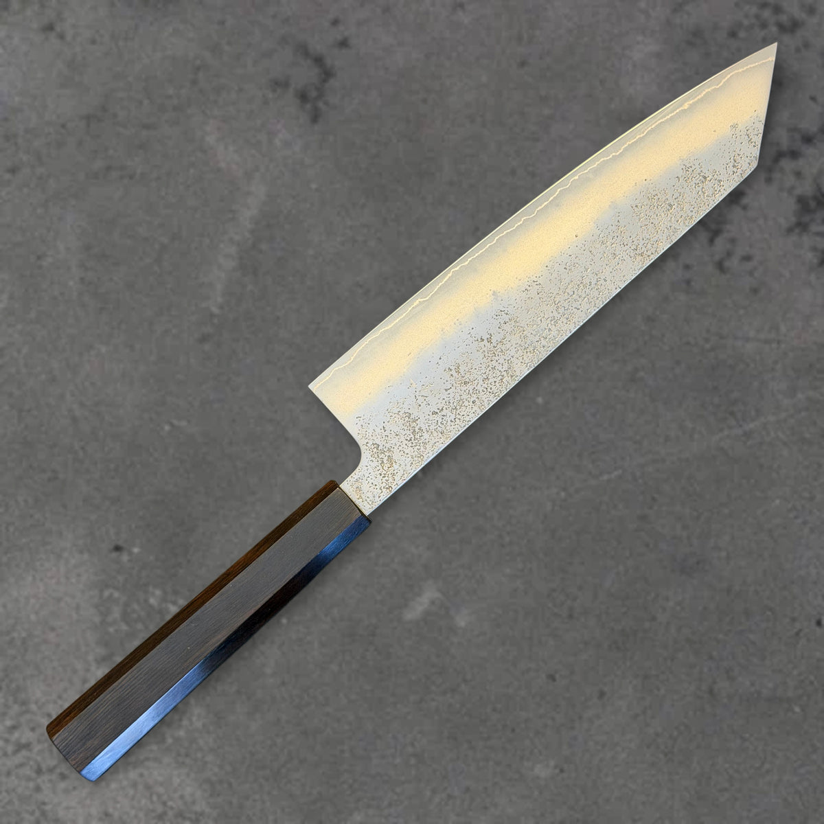 Angled reverse view of the Hatsukokoro Ginrei Ginsan Nashiji 210mm kiritsuke with ebony handle, showing the blade shape, finish, and handle.