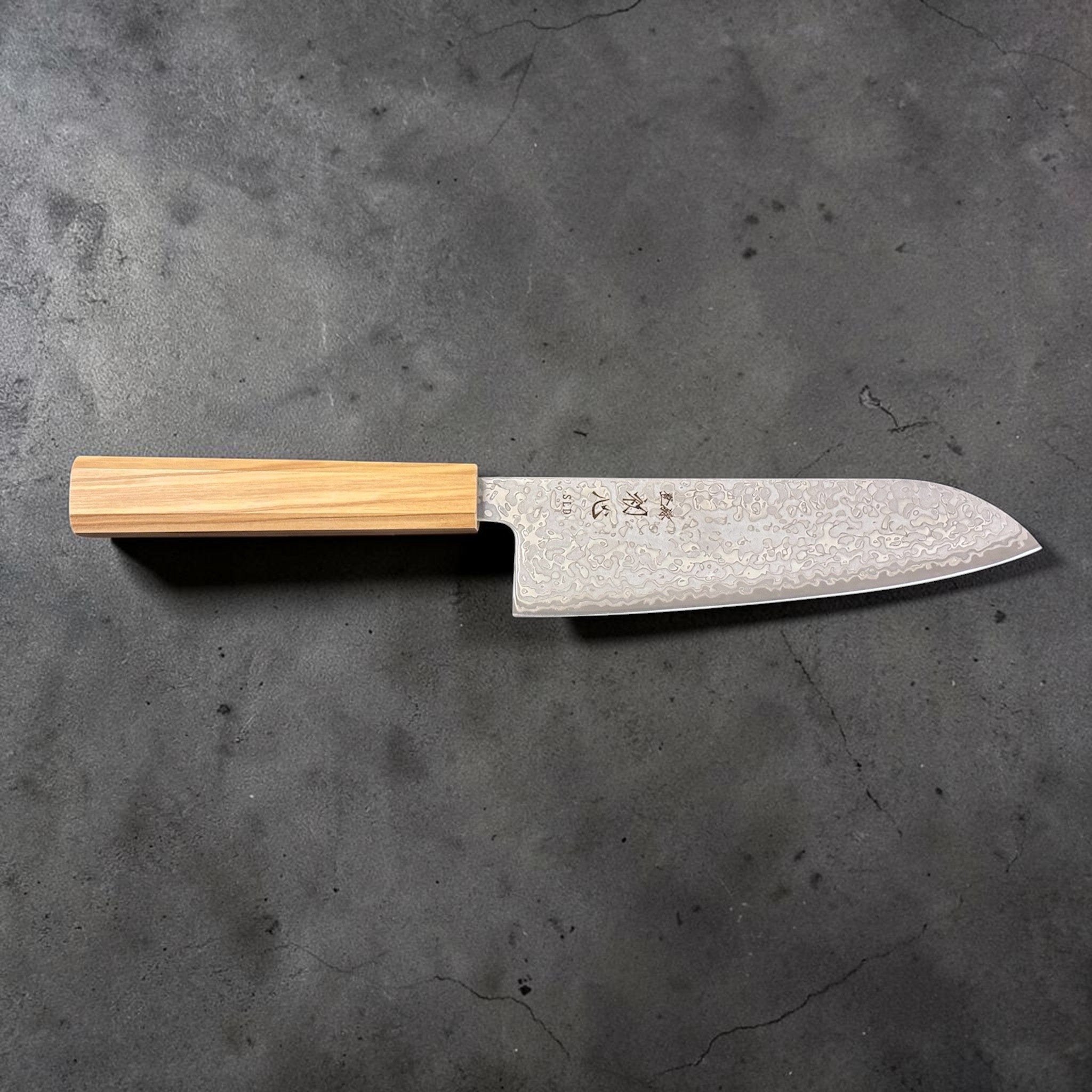 Hatsukokoro Hikari SLD Damascus Santoku 170 mm with olive wood handle, side profile showing blade height and santoku shape; close-up of damascus pattern on the blade.