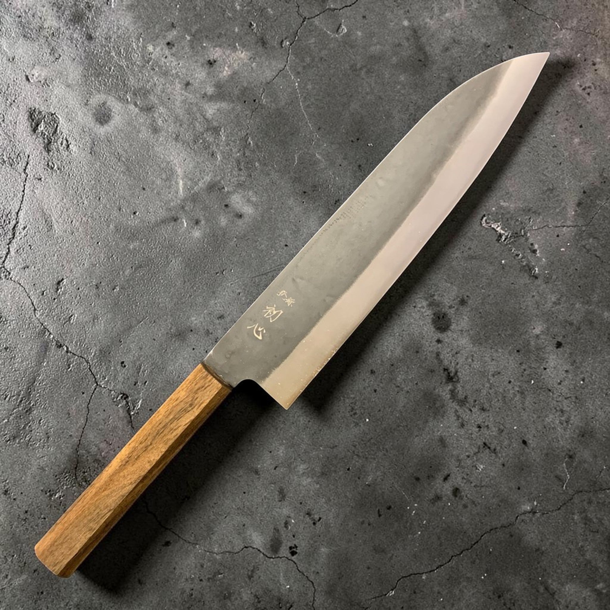 Hatsukokoro Hinomaru White #2 Kurouchi Gyuto 210 mm, right-side view with kurouchi cladding and octagonal wooden wa handle on a black background.