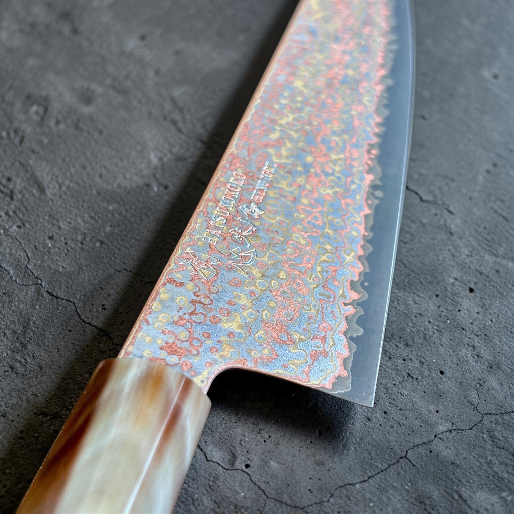 Hatsukokoro Hinotori V-Toku2 Rainbow Damascus Gyuto 240 mm, spine-view close-up showing the thin grind and horn ferrule.