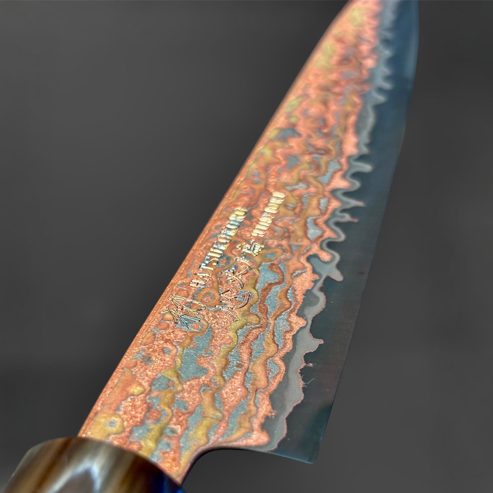 Hatsukokoro Hinotori V-Toku2 Rainbow Damascus Petty 150 mm with Amboyna Burl handle, close-up of engraved rainbow Damascus pattern near the heel.