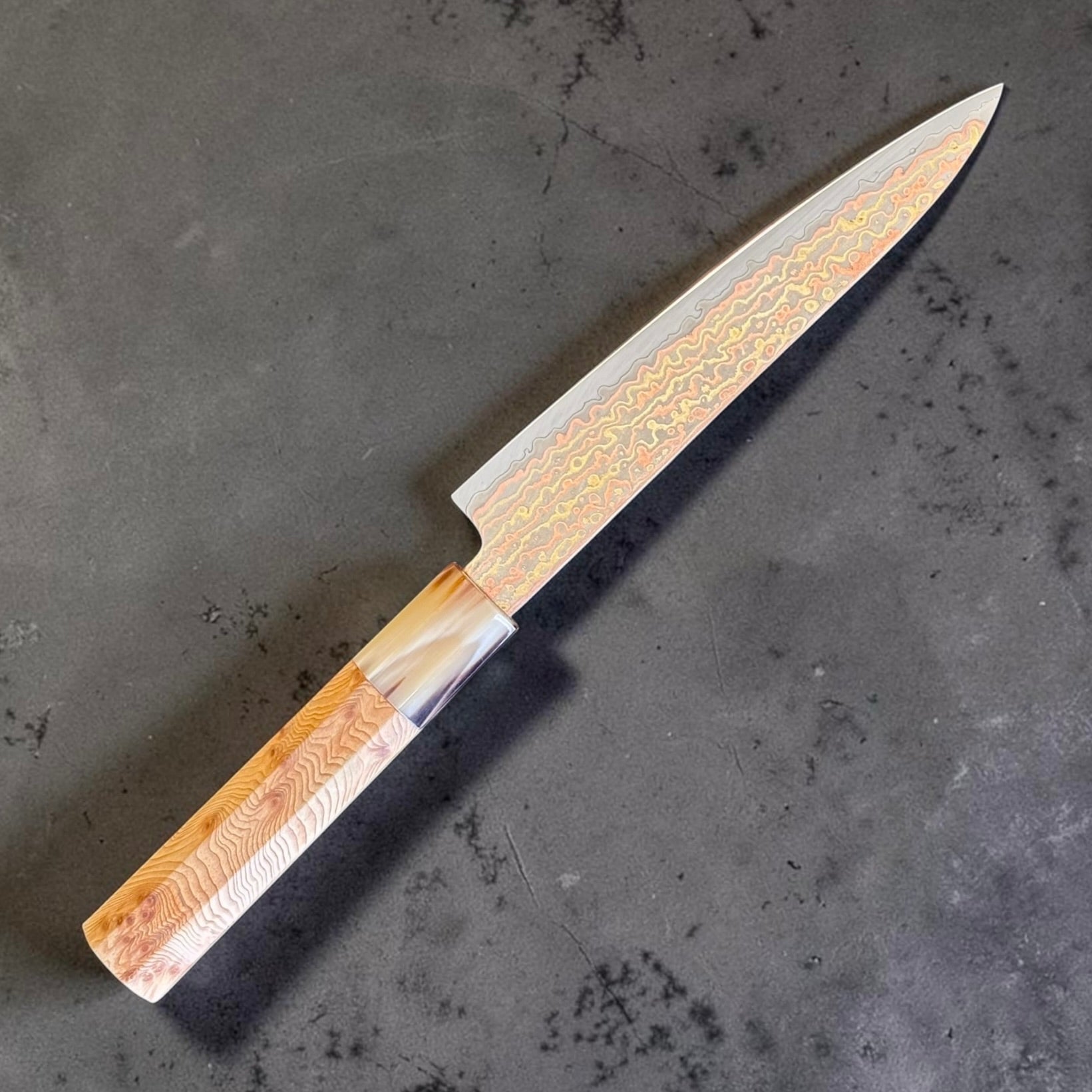 Hatsukokoro Hinotori V-Toku2 Rainbow Damascus Petty 150mm with cypress wood and buffalo horn wa handle, angled left-side view.