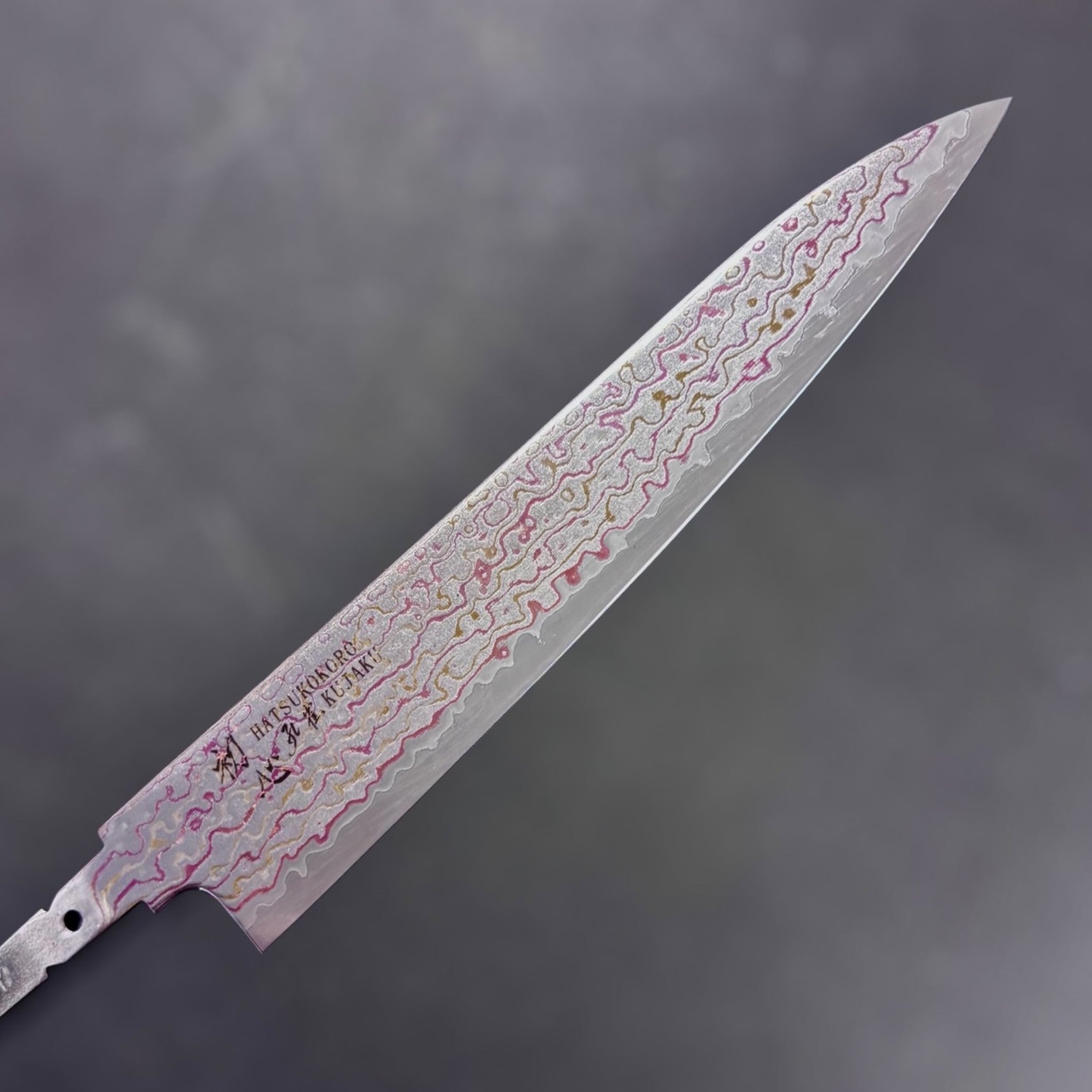 Hatsukokoro Kujaku V-Toku2 Rainbow Damascus Petty 150 mm, tight crop on rainbow-layered damascus near the tip, blade only (no handle).