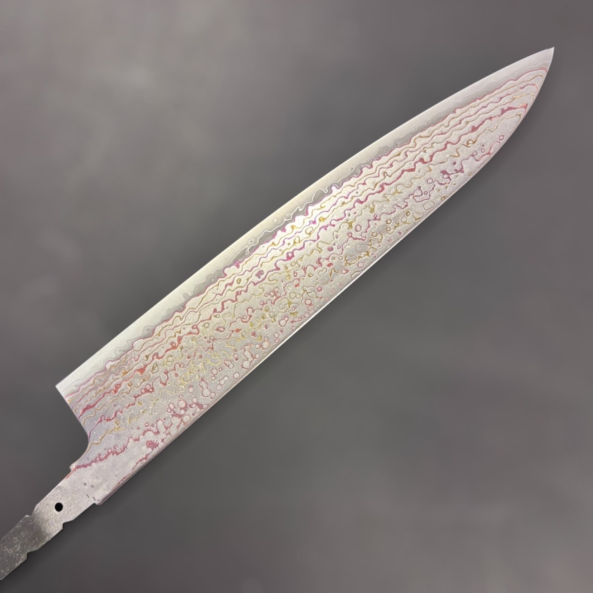 Hatsukokoro Kujaku V-Toku2 Rainbow Damascus Gyuto 210 mm (no handle), reverse-side blade view with circular and wavy damascus layers.