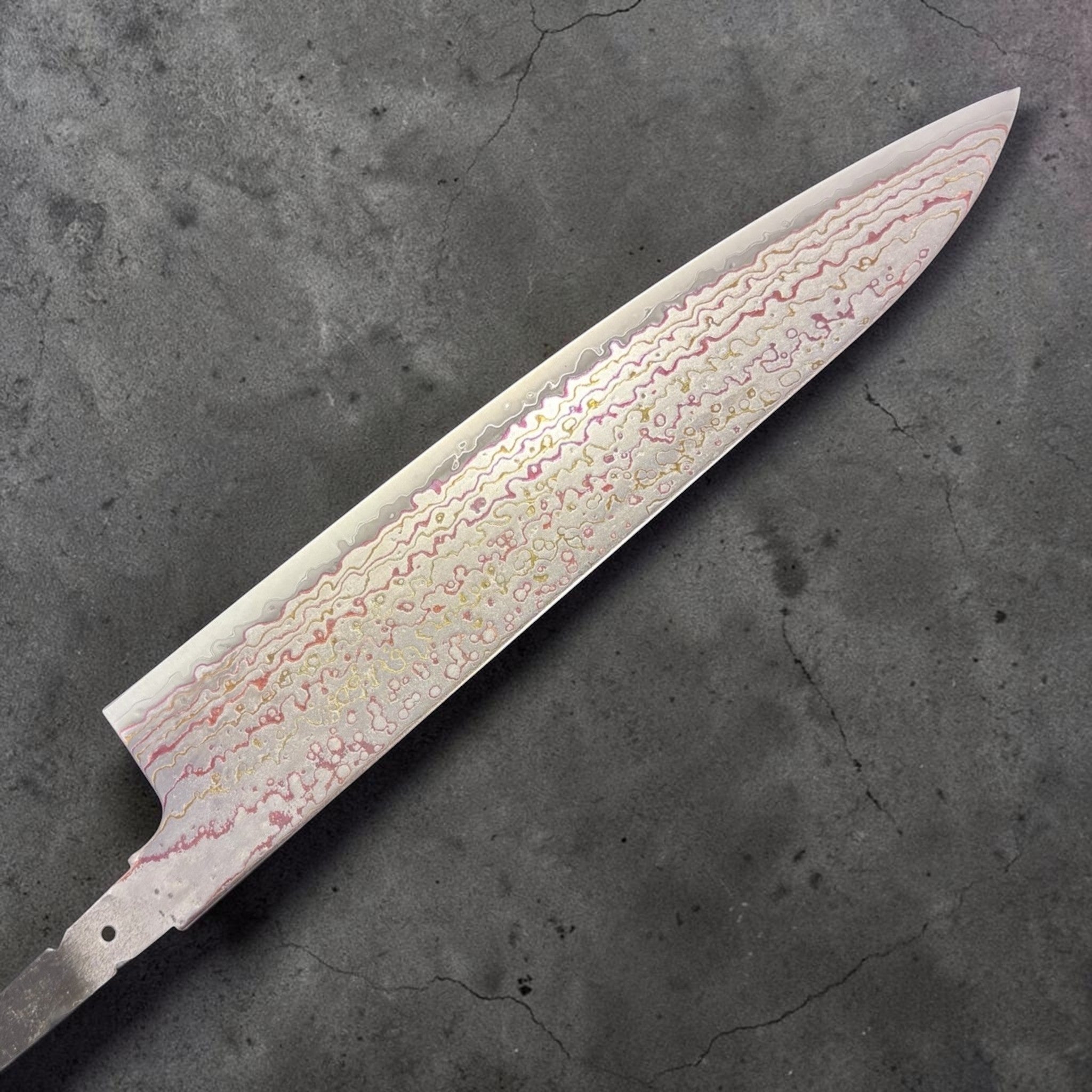 Hatsukokoro Kujaku V-Toku2 Rainbow Damascus Gyuto 210 mm (no handle), reverse-side blade view with circular and wavy damascus layers.