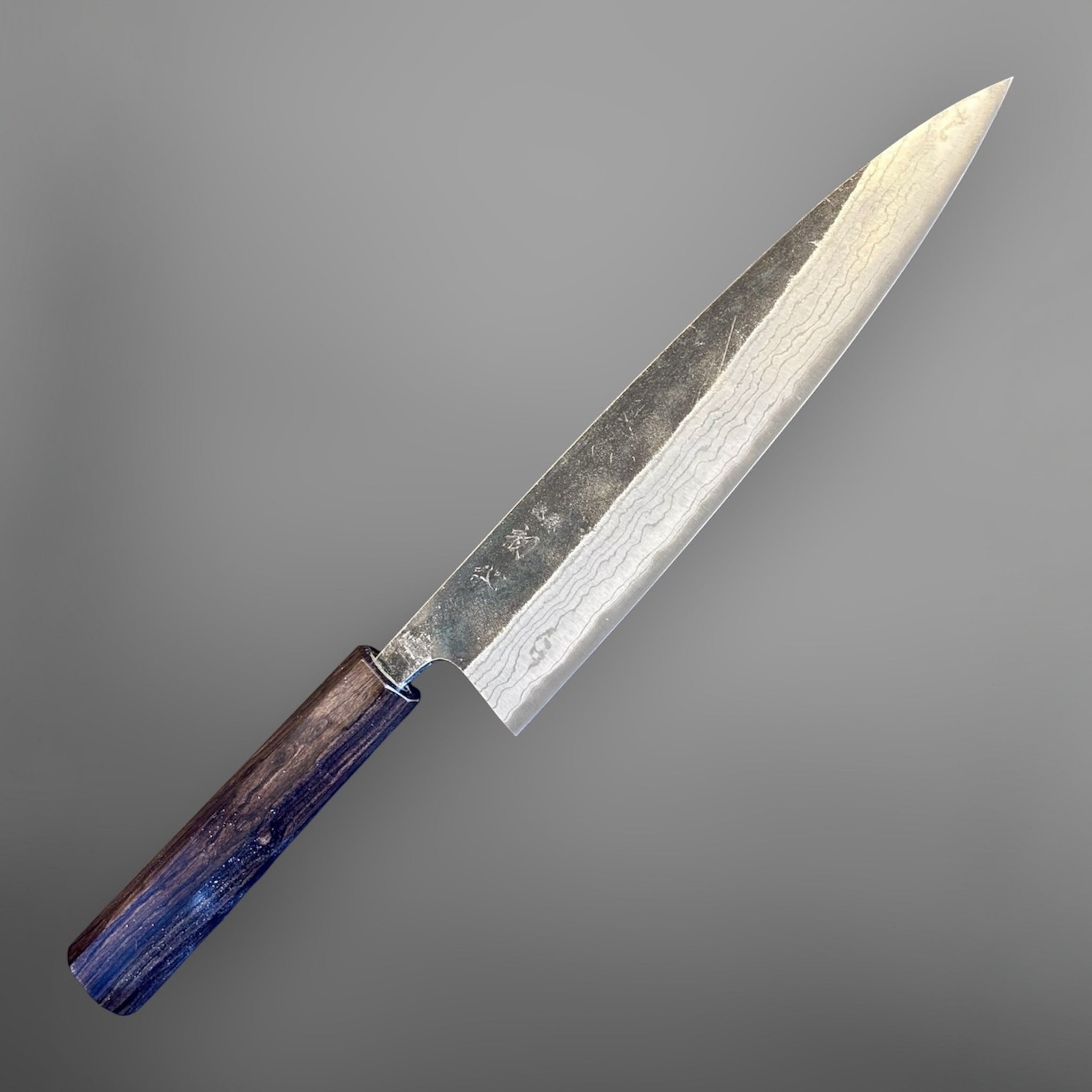 Hatsukokoro Kumokage Blue #2 Gyuto 240 mm with mono ebony handle, angled full-knife product view on a grey background.
