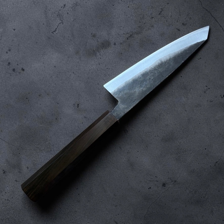 Reverse angled view of the Hatsukokoro Kurogane Blue #2 Kurouchi Honesuki 150mm with mono ebony handle.