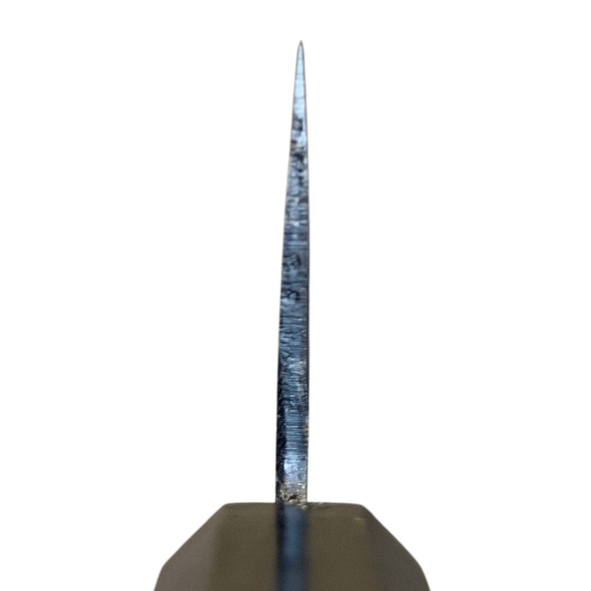 Close-up choil view of the Hatsukokoro Kurogane Blue #2 Kurouchi 210mm gyuto with ebony handle, showing the blade cross-section and grind against a white background.