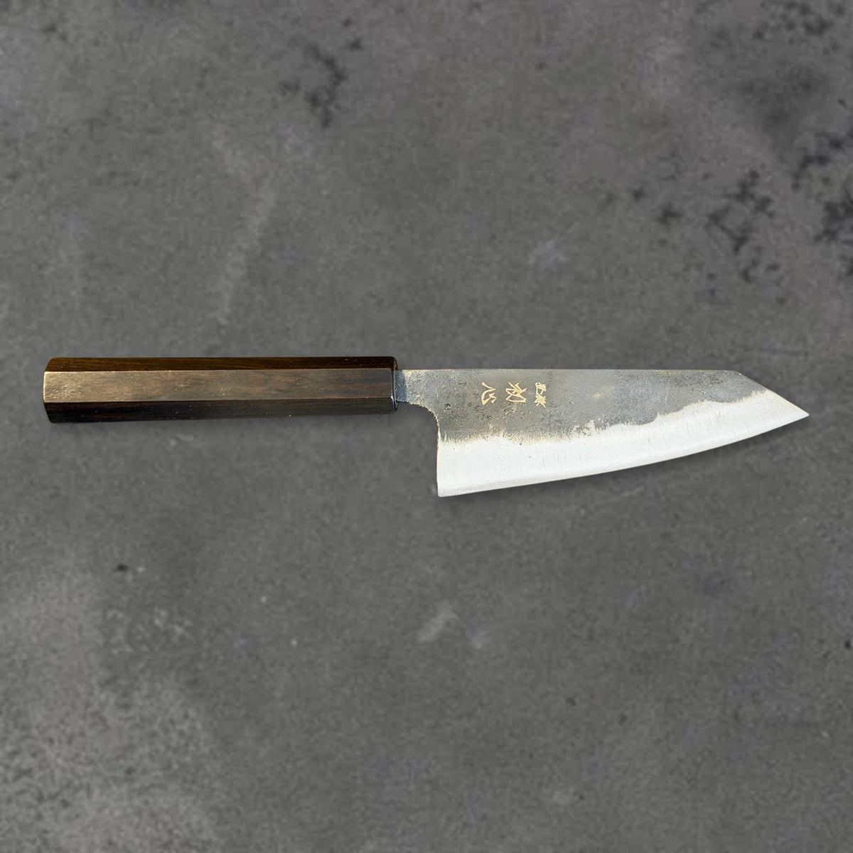 Hatsukokoro Kurogane Blue #2 Kurouchi 120mm ko-bunka with ebony handle, shown in horizontal front profile with the full blade and handle visible.
