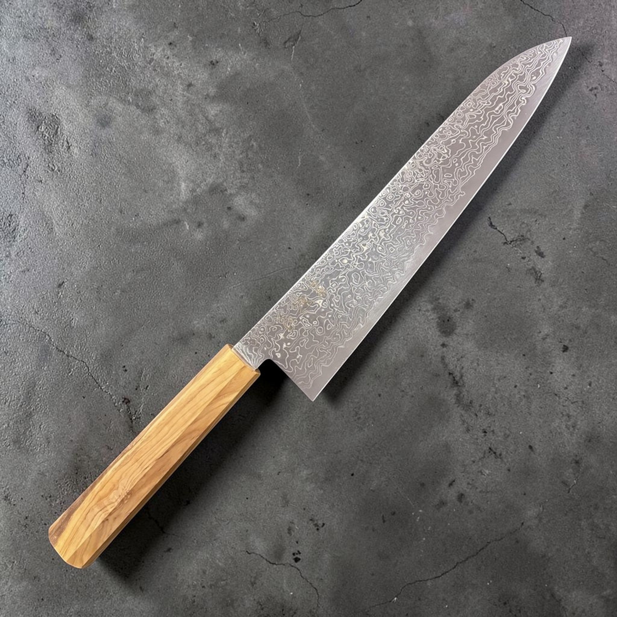 Hatsukokoro Ryuhyo SG2 Damascus Gyuto 240 mm, front view displaying the swirling Ryuhyo Damascus pattern and olivewood wa handle.