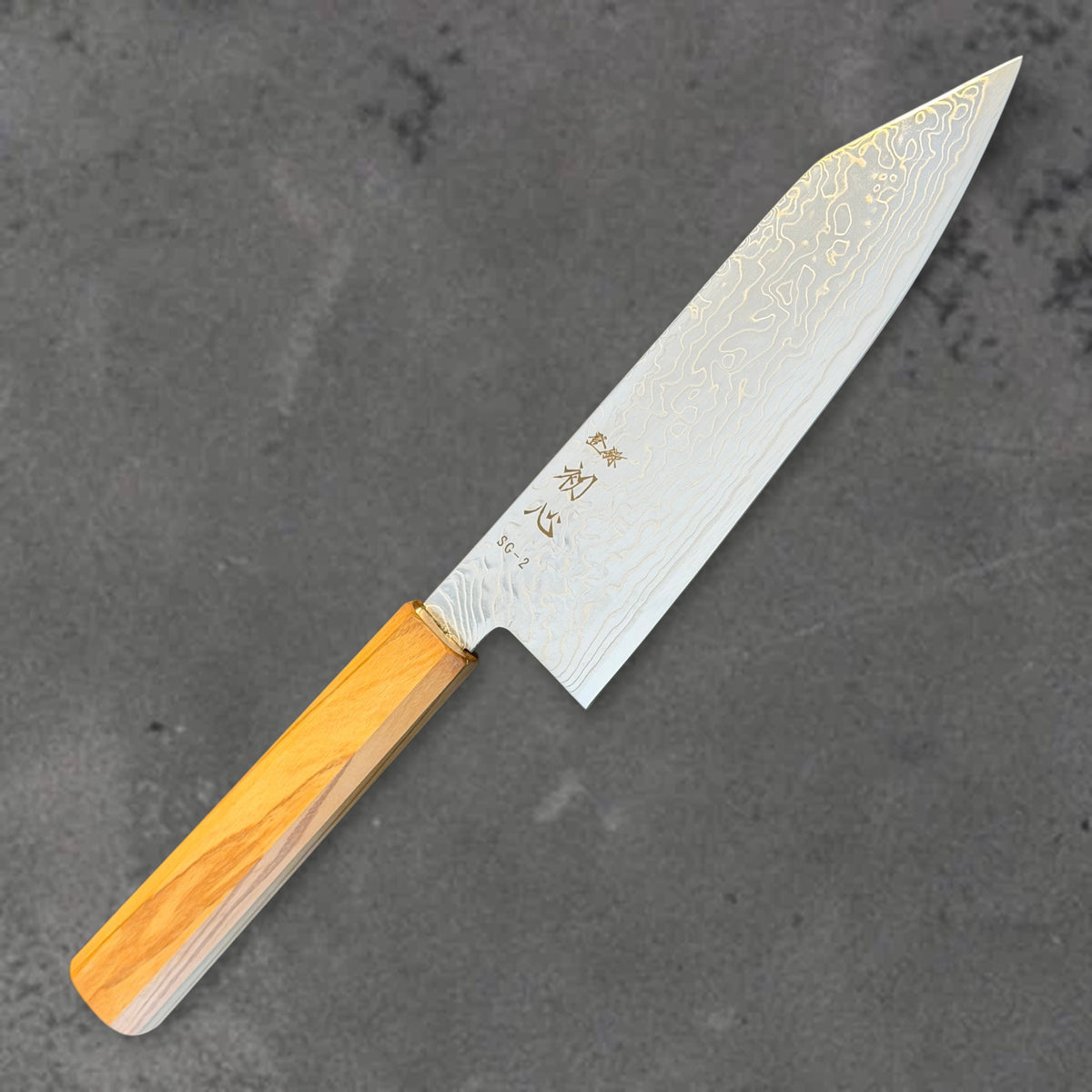Angled front view of the Hatsukokoro Ryuhyo SG2 Damascus 180mm bunka with olive wood handle, showing the blade shape, finish, and handle. #Handle_Mono Olive Wood