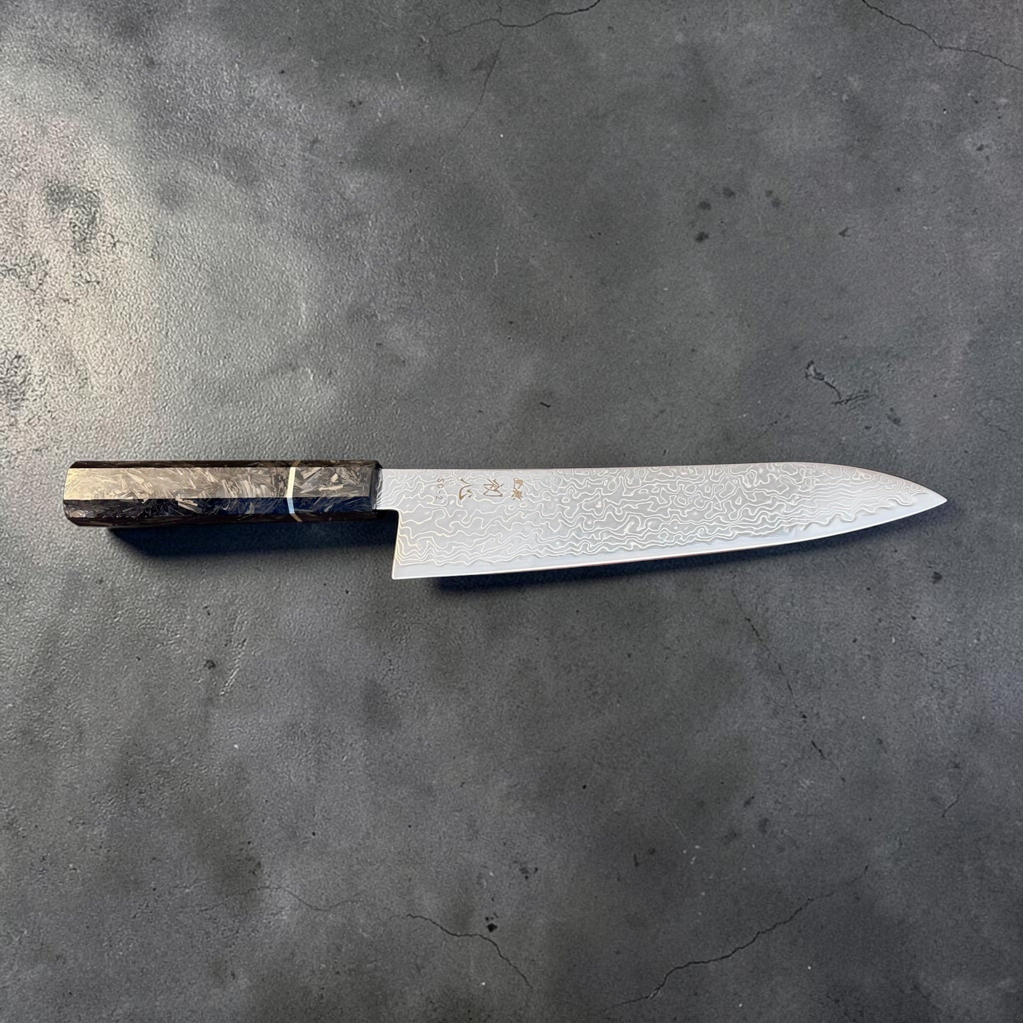 Reverse side profile of the Hatsukokoro Ryuhyo SG2 Damascus Gyuto 210mm showing the polished Damascus blade.