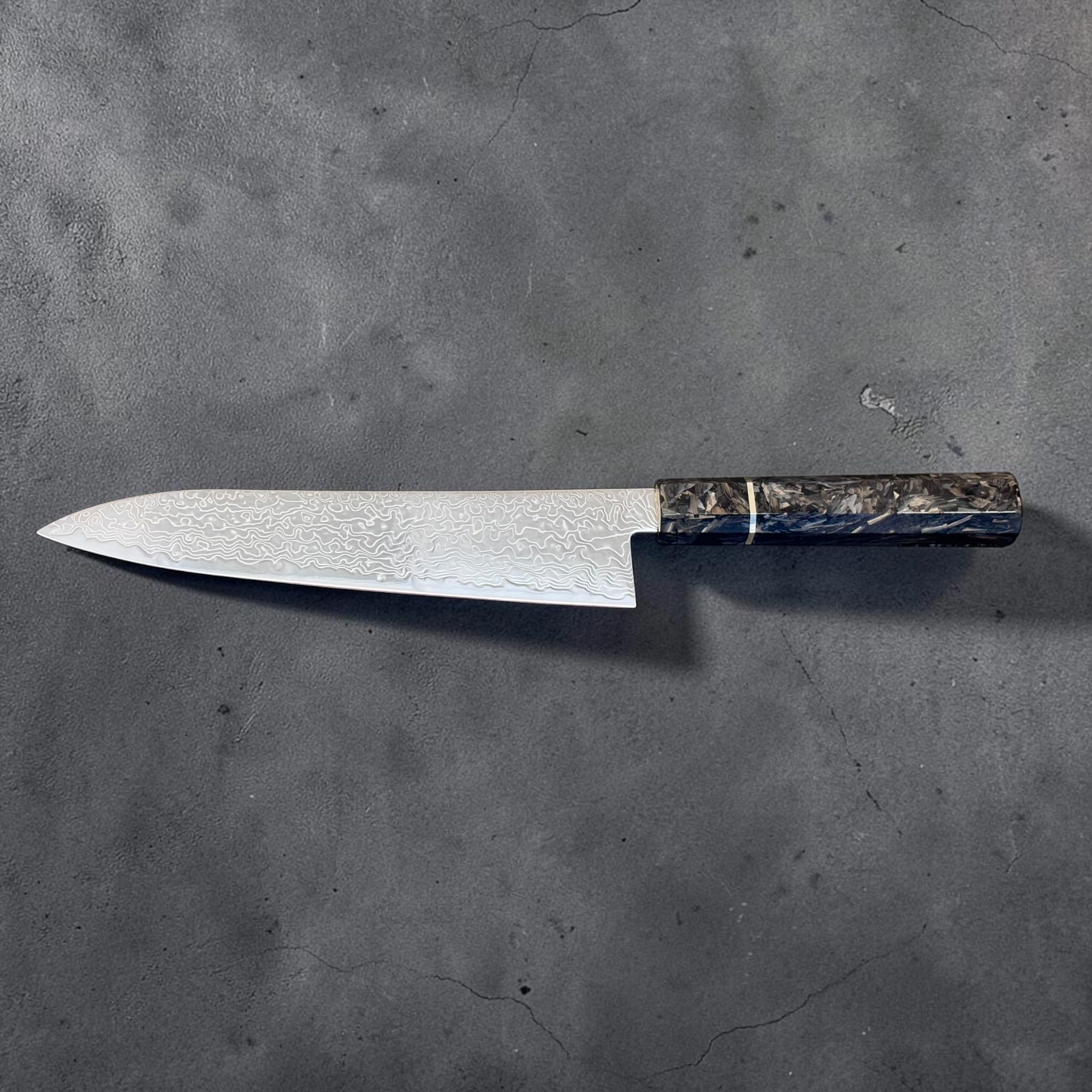 Full side profile of the Hatsukokoro Ryuhyo SG2 Migaki Damascus Gyuto 210mm with carbon fiber handle.