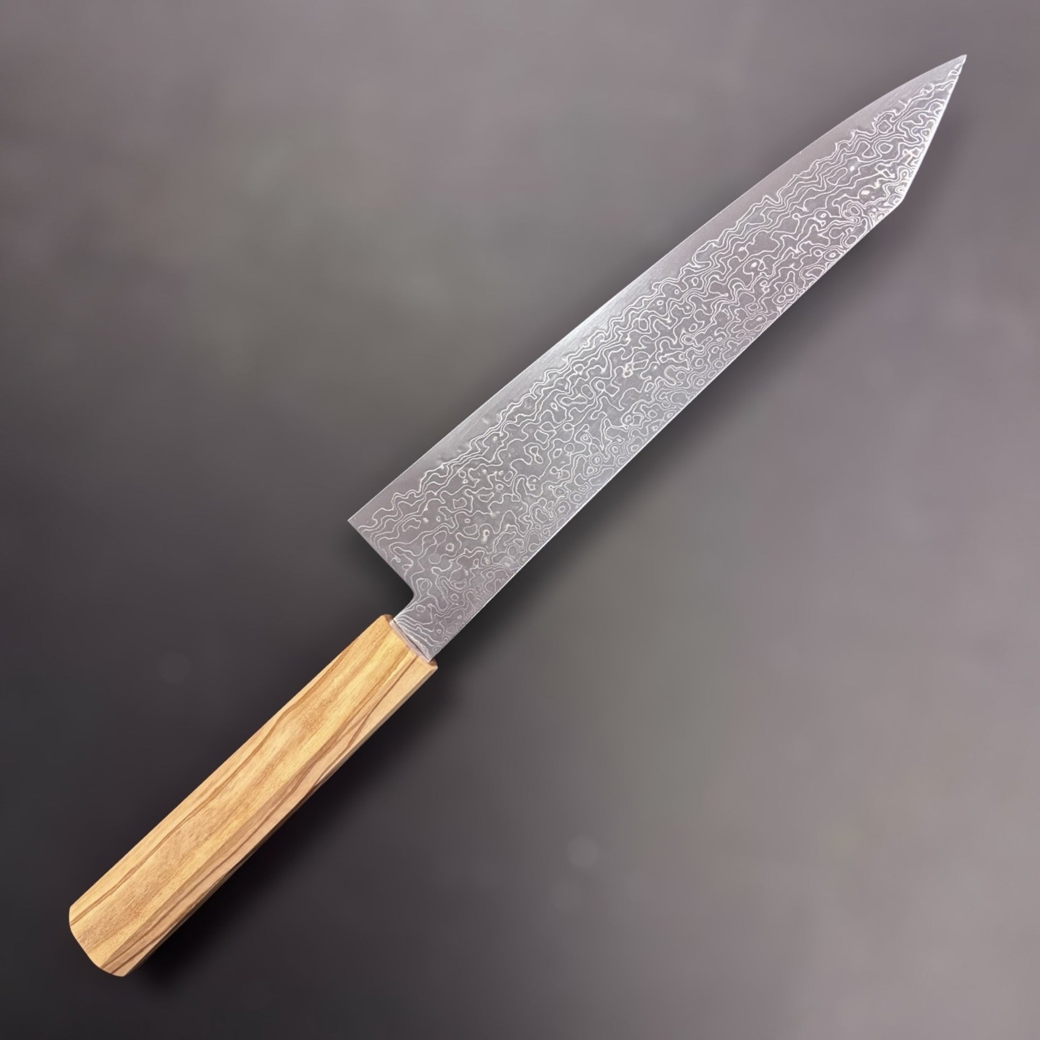 Hatsukokoro Ryuhyo SG2 Damascus Kiritsuke 240 mm, left side showcasing the intricate Damascus pattern and unique kiritsuke tip with an olive wood handle.