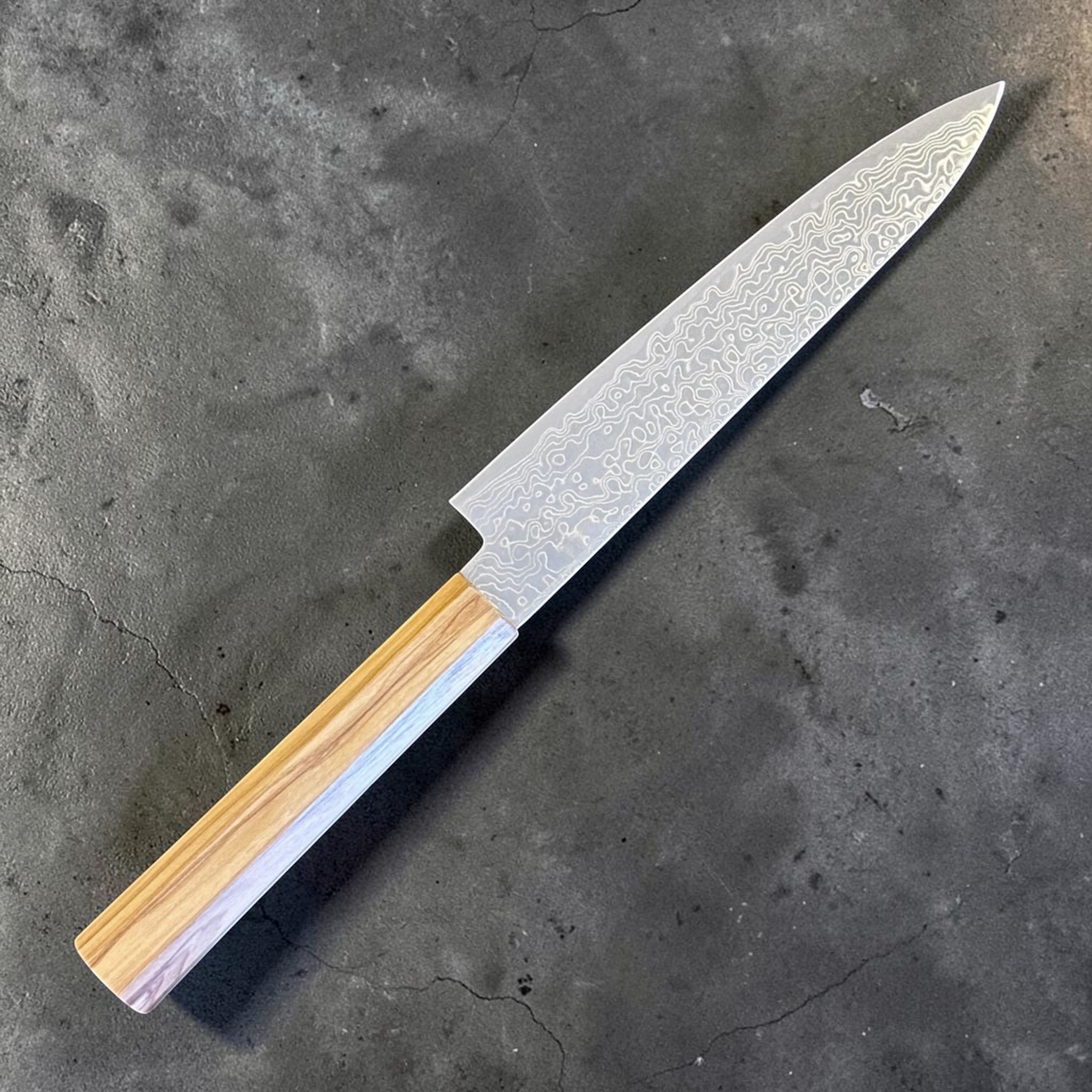 Hatsukokoro Ryuhyo SG2 Damascus Petty 150 mm with olive wood handle, close angled product shot showing the Damascus pattern and wa handle grain.