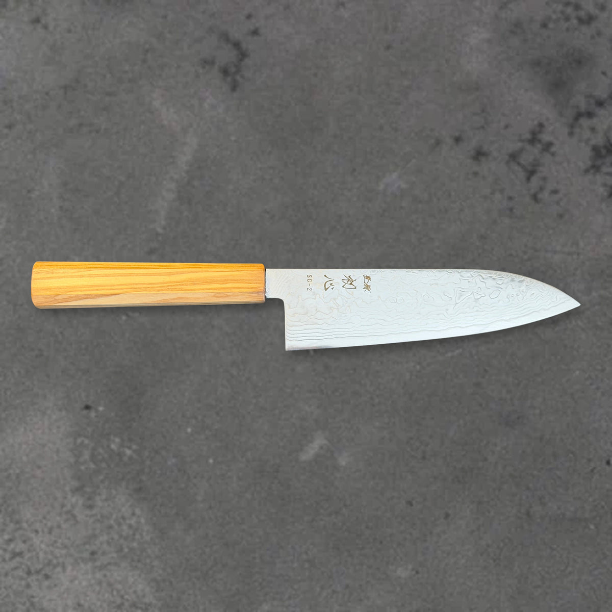 Hatsukokoro Ryuhyo SG2 Damascus santoku with olive wood handle, shown in horizontal front profile with the full blade and handle visible.