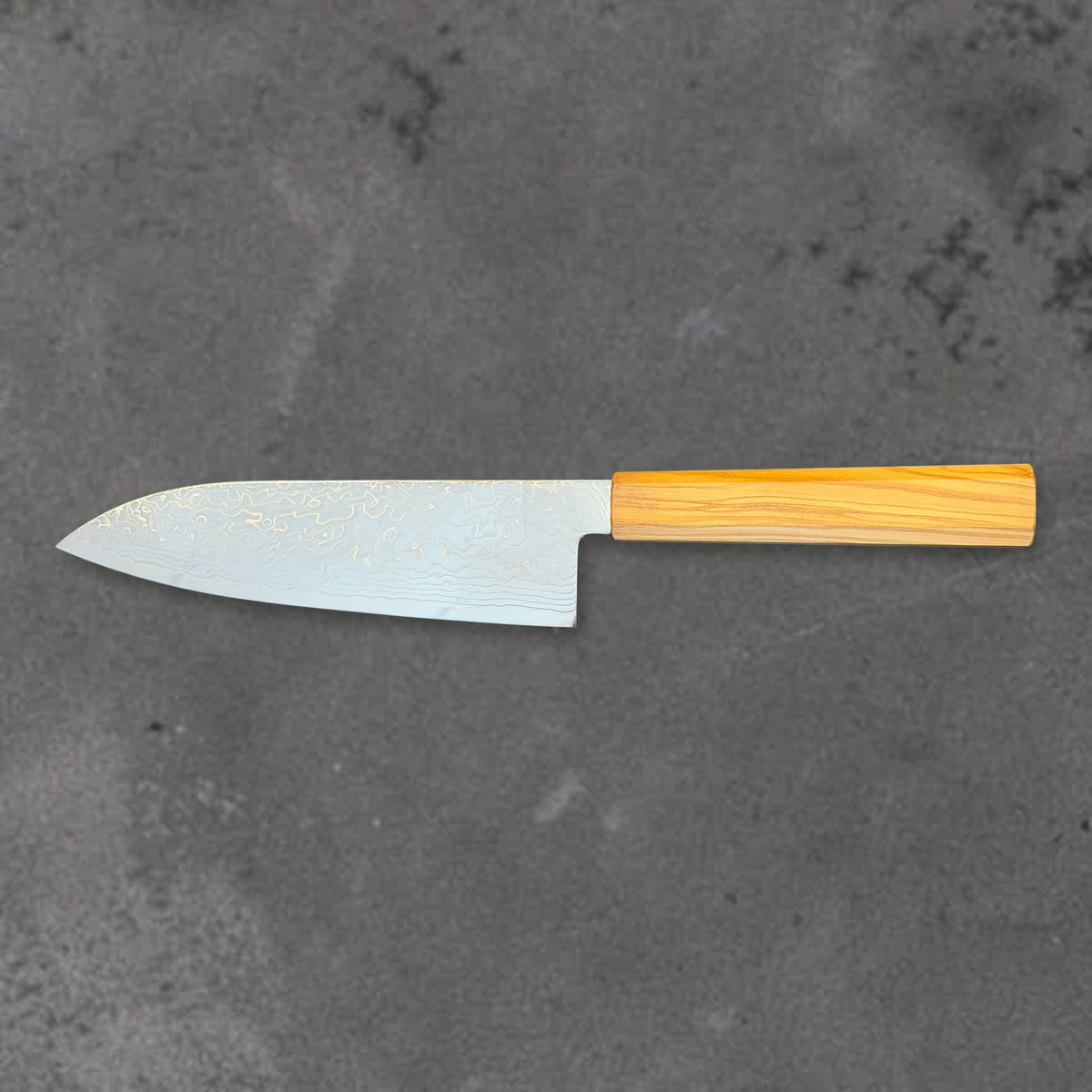 Hatsukokoro Ryuhyo SG2 Damascus santoku with olive wood handle, shown in horizontal reverse profile with the full blade and handle visible.