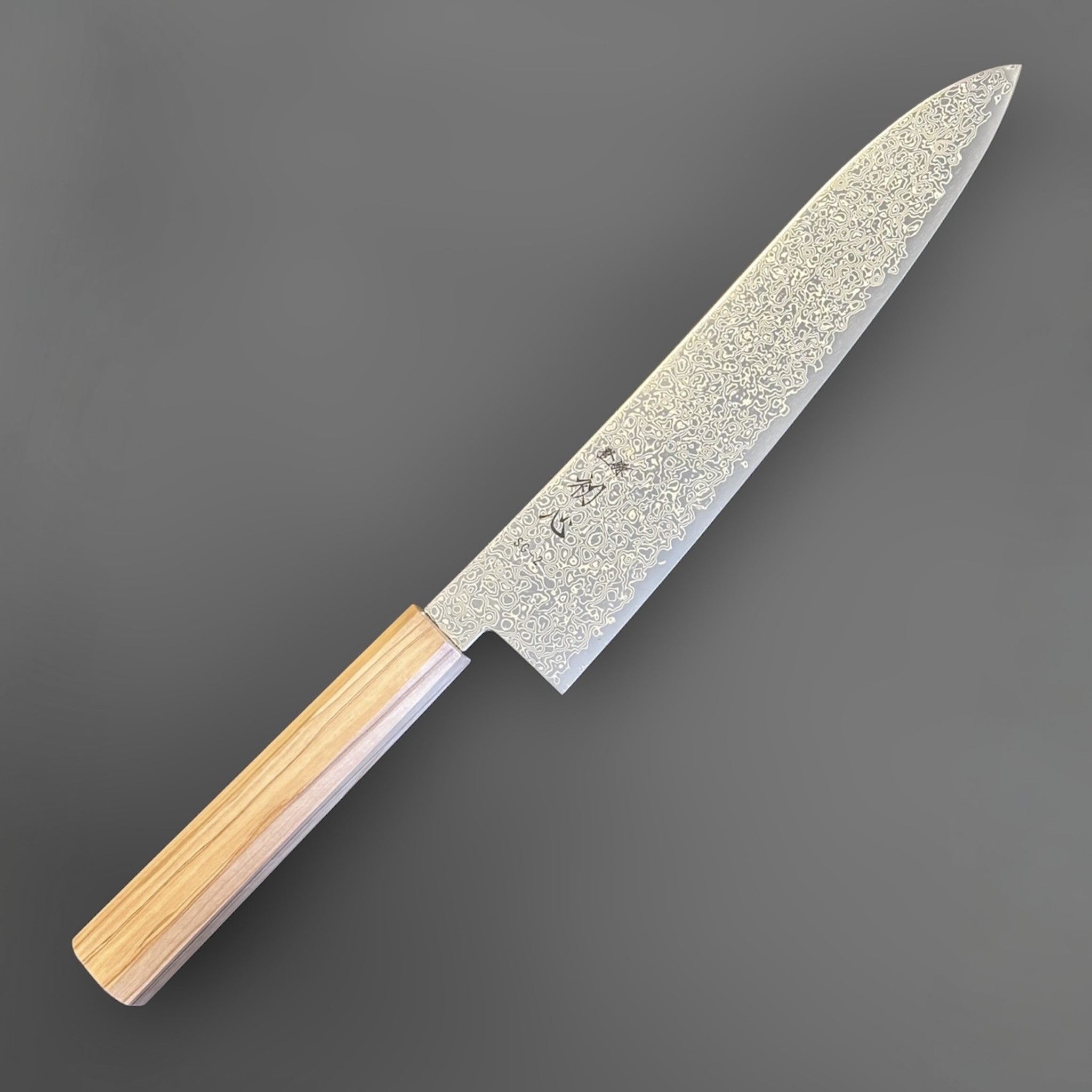Hatsukokoro Saihyo SG2 Damascus Gyuto 210 mm with mono olive handle, angled full-knife view showing the etched Damascus blade pattern.