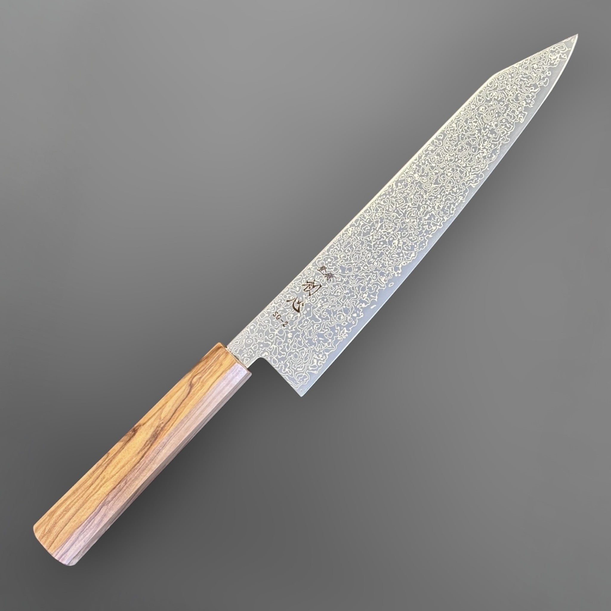 Hatsukokoro Saihyo SG2 Damascus Kiritsuke 240mm with Mono Olive Wood Handle, angled full-length product view showing the SG2 Damascus kiritsuke blade and mono olive wood wa handle.