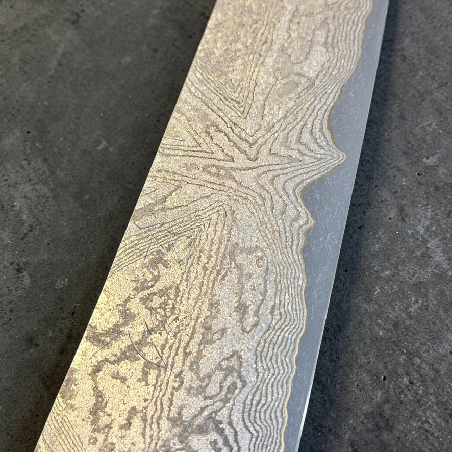 Close-up of the flowing Damascus pattern and kanji near the heel of the Hatsukokoro VG-XEOS Gyuto 210mm blade.