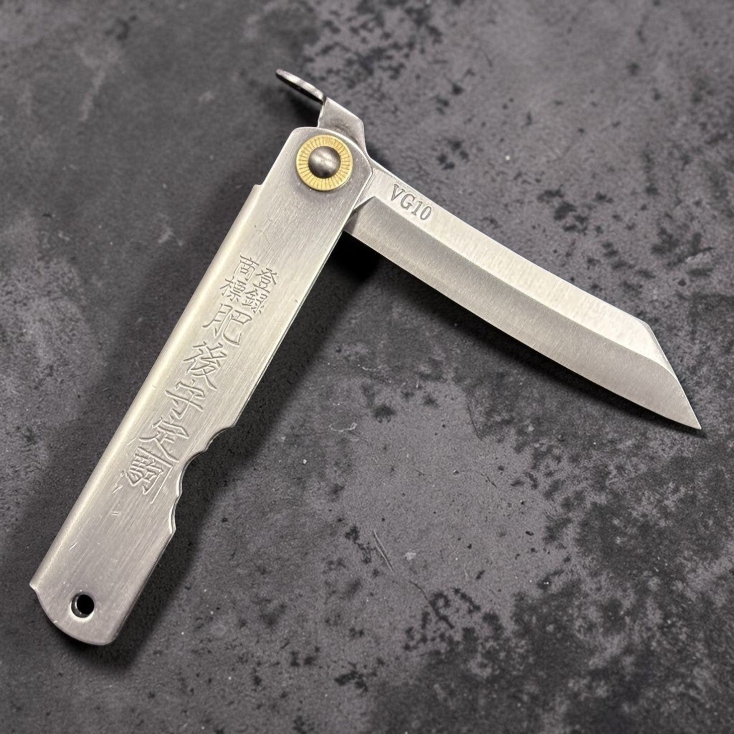 Higonokami VG-10 Japanese pocket knife, medium size, diagonal open view on dark background.