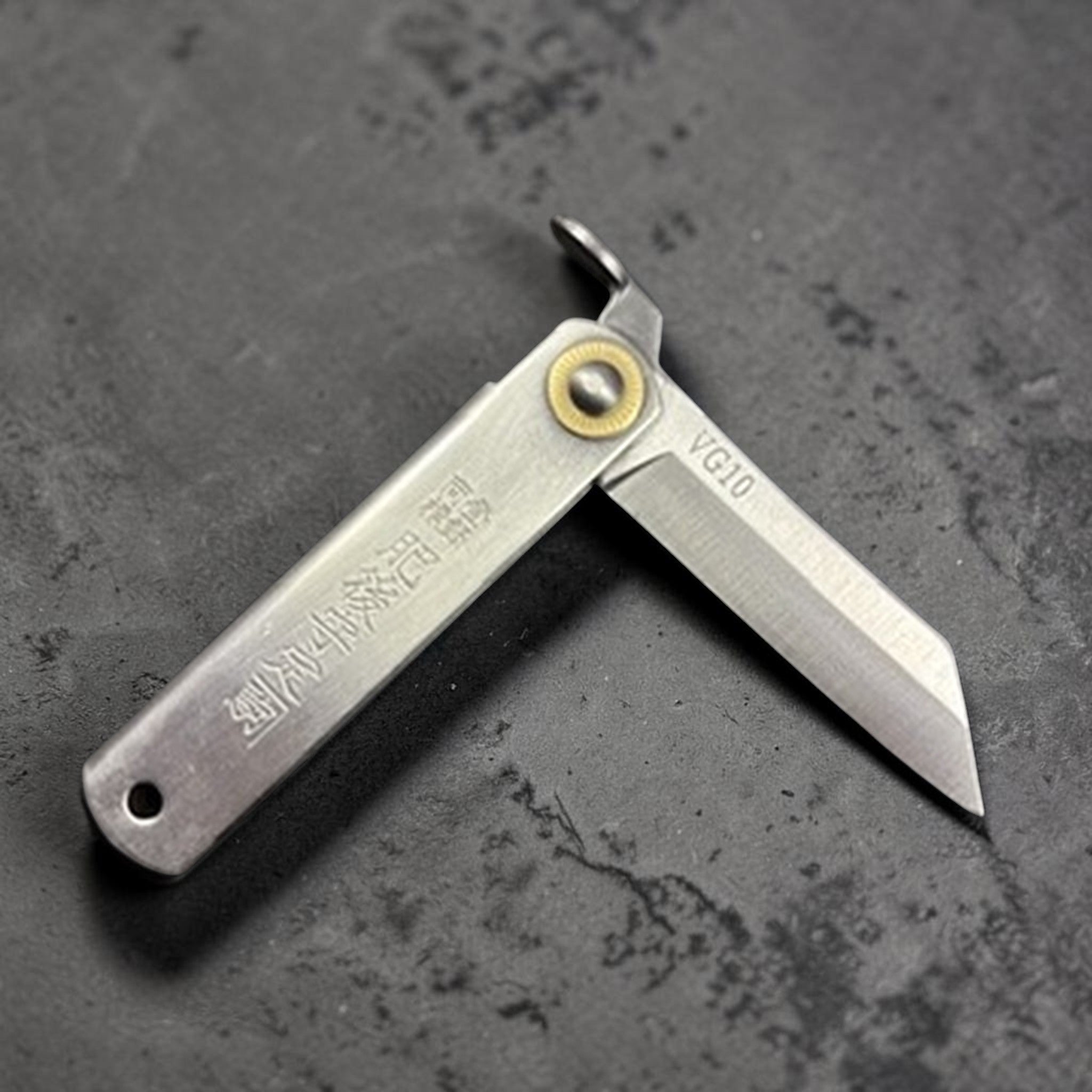 Higonokami VG‑10 Japanese pocket knife (Small), open at a right angle showing the kanji stamp and brass pivot.
