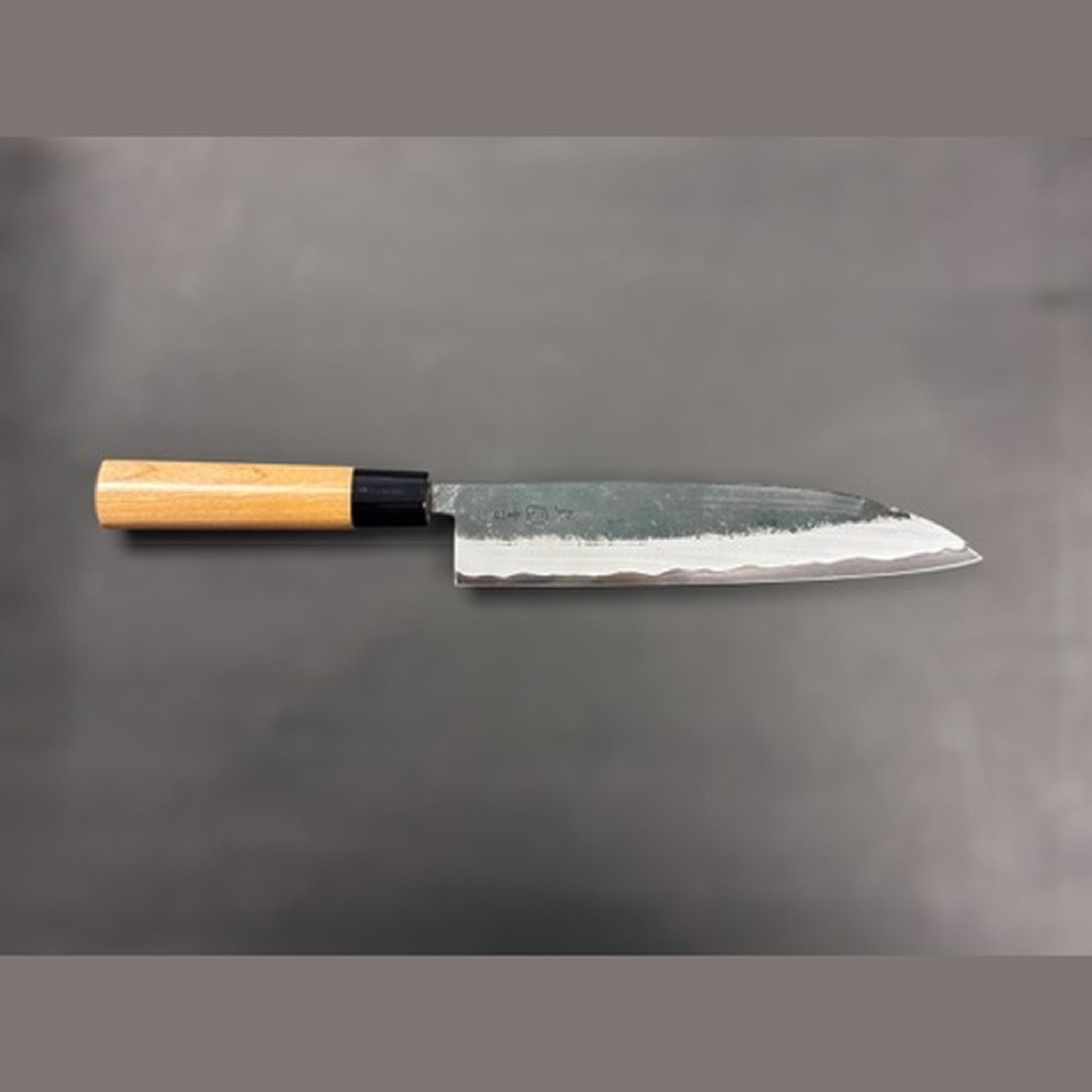 Hinokuni Aogami Super Kurouchi Gyuto 210 mm, profile side view of the blade on a neutral background.