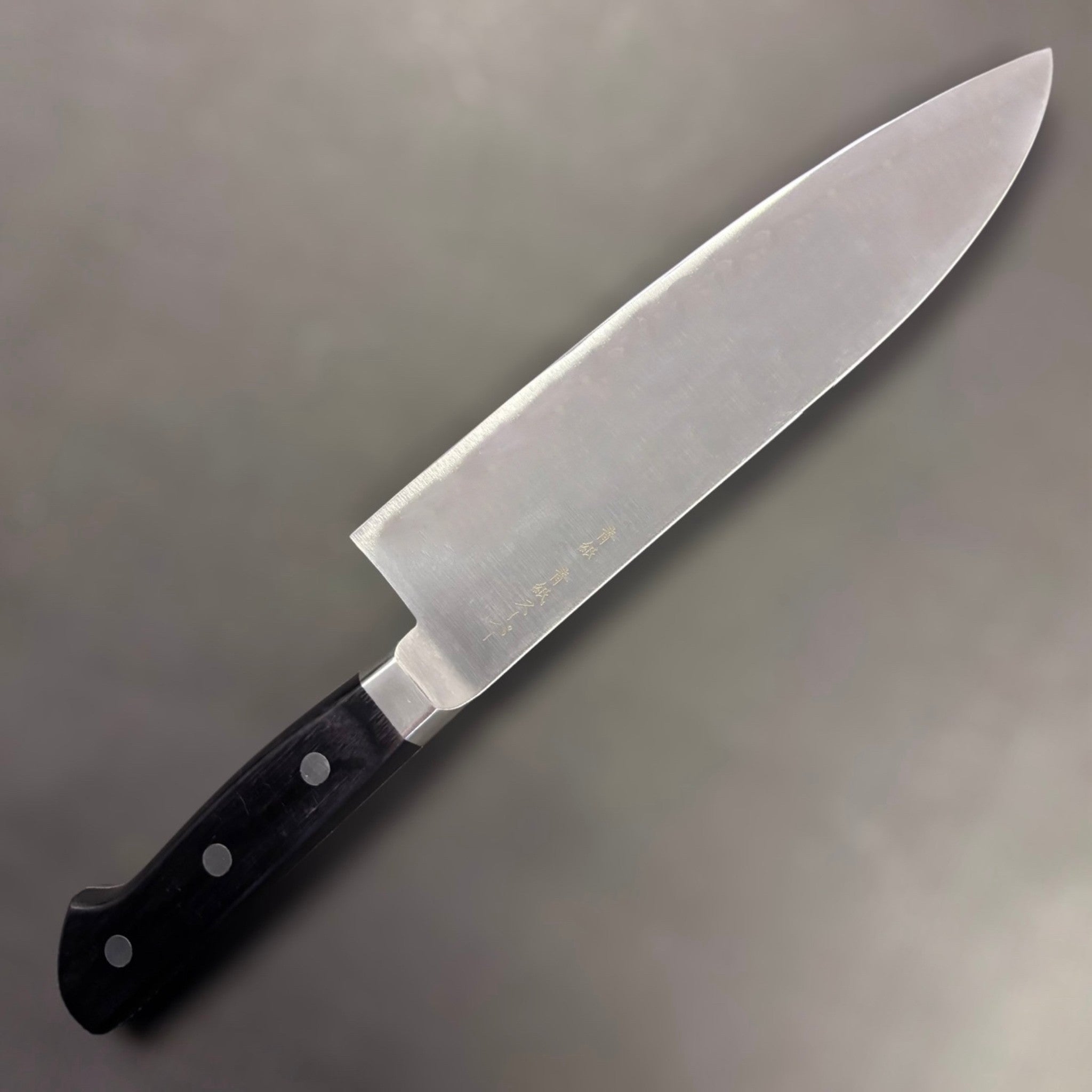 Ittetsu AS Santoku 180 mm, three-quarter hero angle showing kanji and belly curve.
