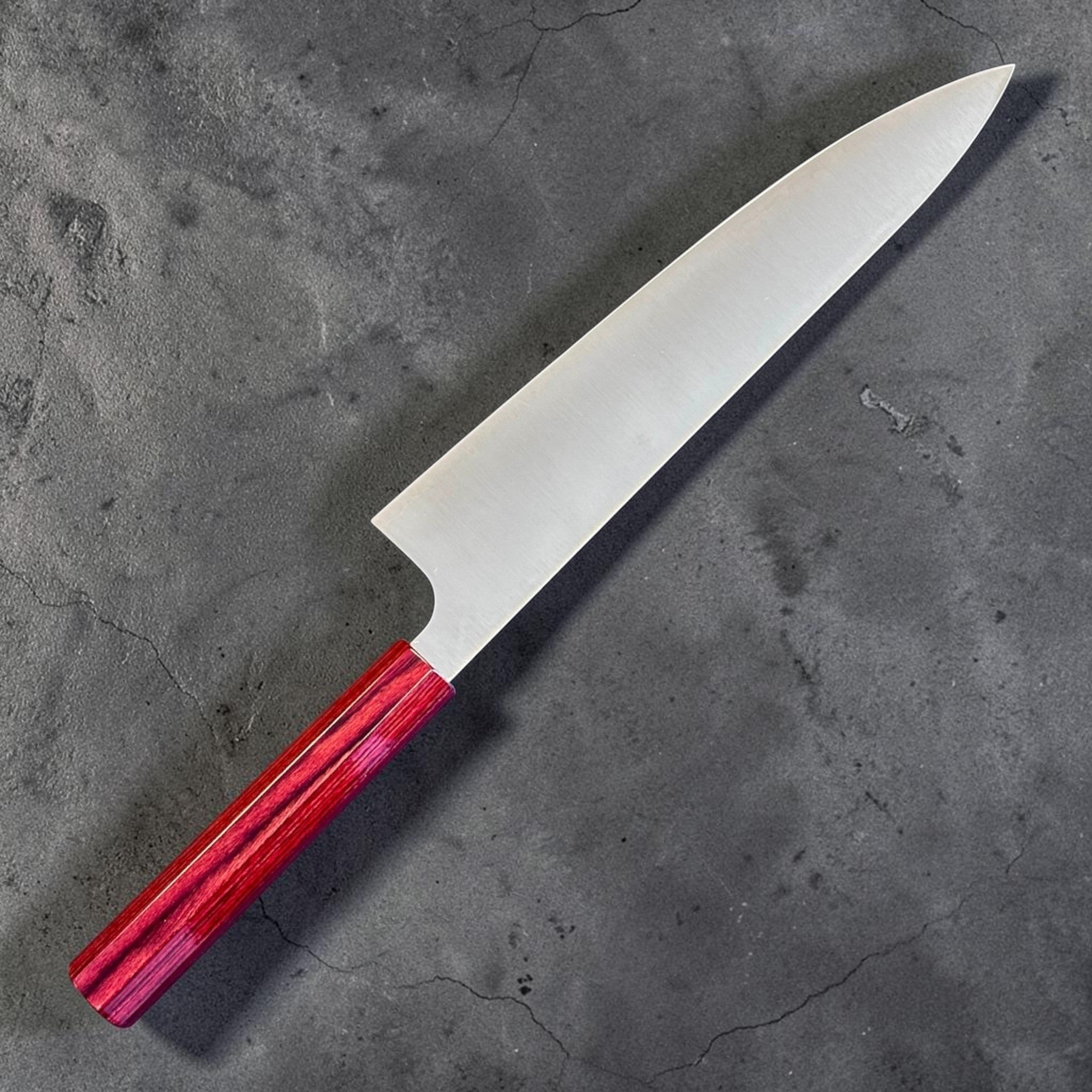 Kei Kobayashi SG2 Gyuto 210 mm with red lacquer handle, angled reverse-side view emphasizing the laser-thin profile and fine tip geometry.