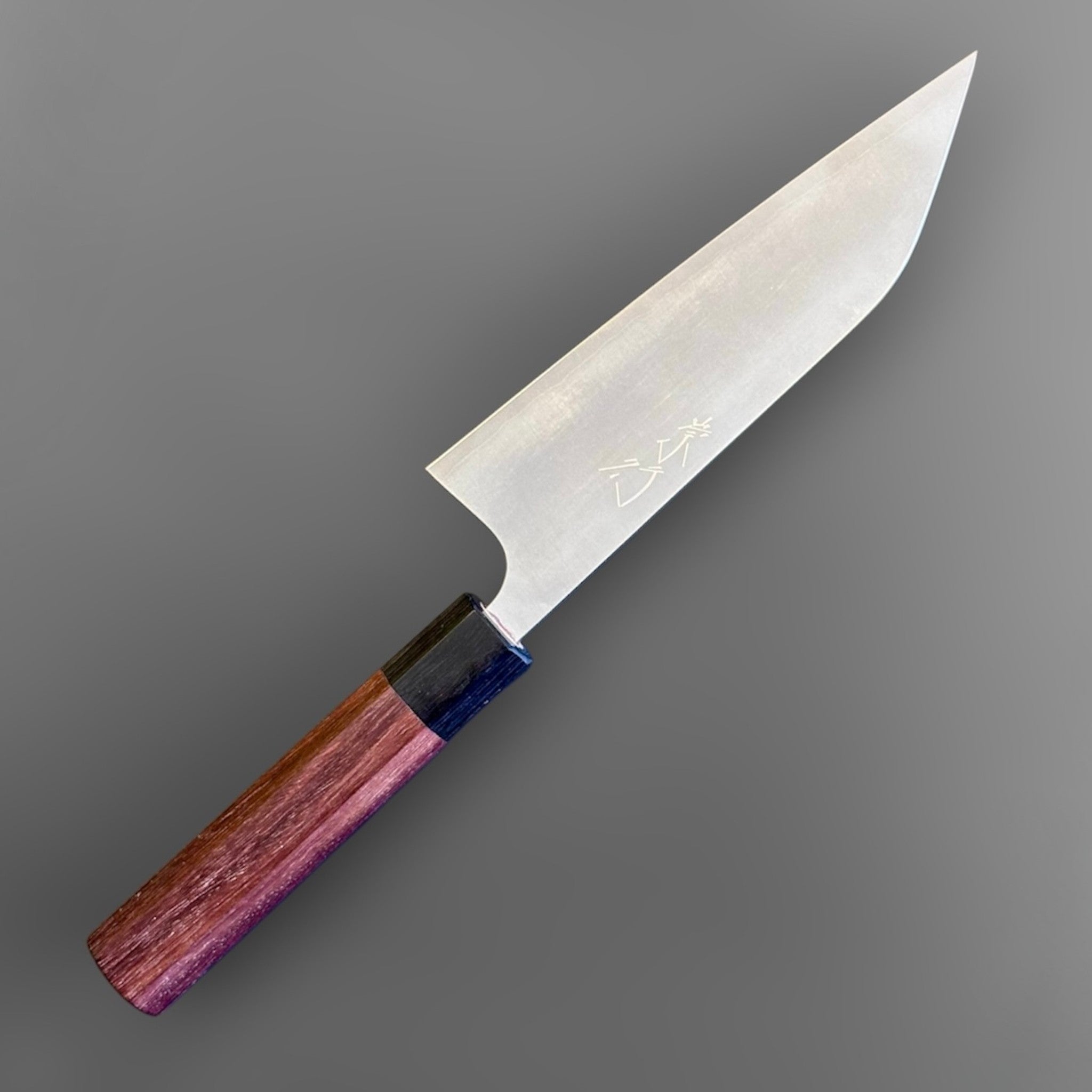 Koutetsu Chromax Santoku with rosewood octagon handle, angled reverse-side view highlighting the clean blade face, engraved kanji, and rosewood wa handle.