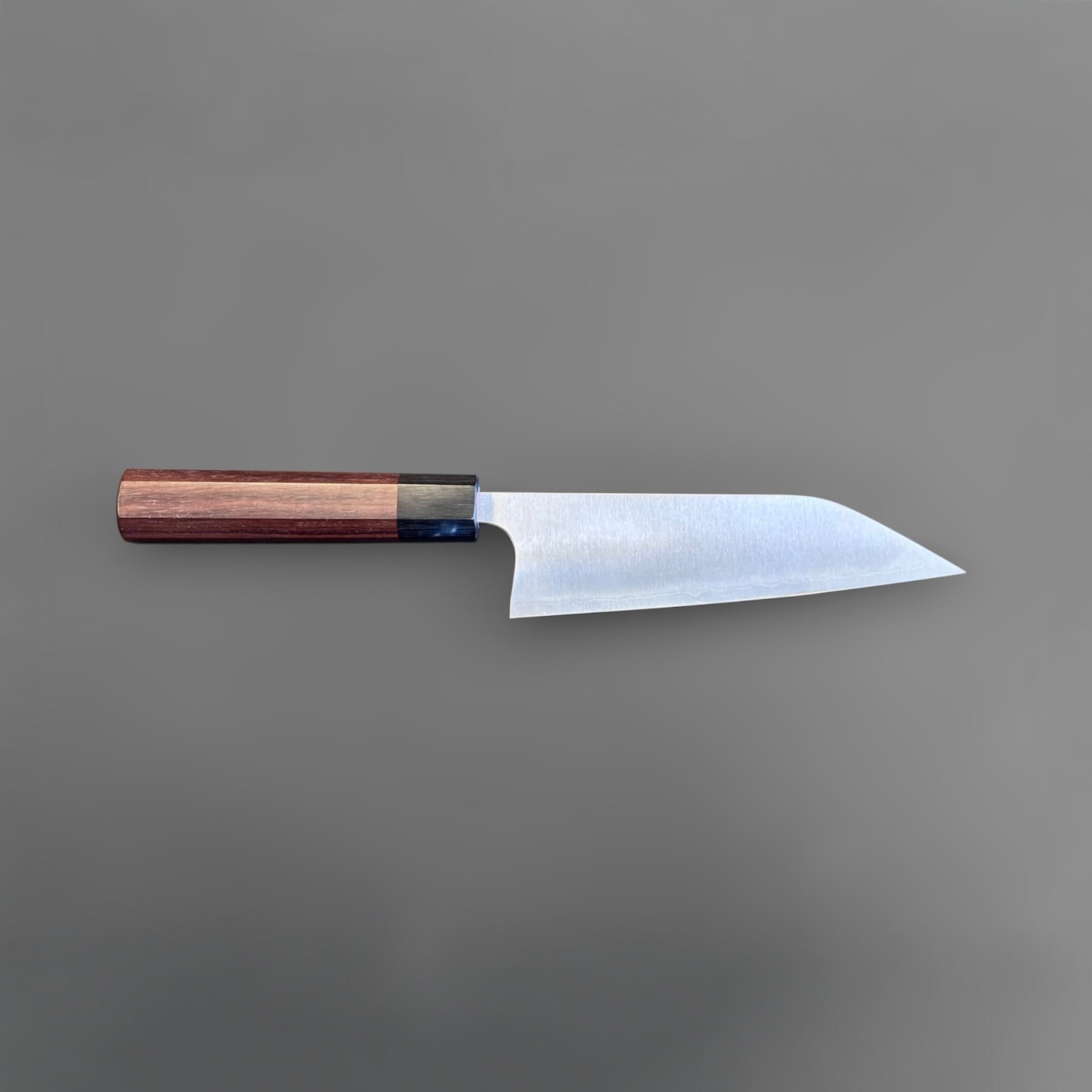 Koutetsu Chromax Santoku with rosewood octagon handle, full profile showing the tall santoku blade, kiritsuke-style tip, and octagonal handle.