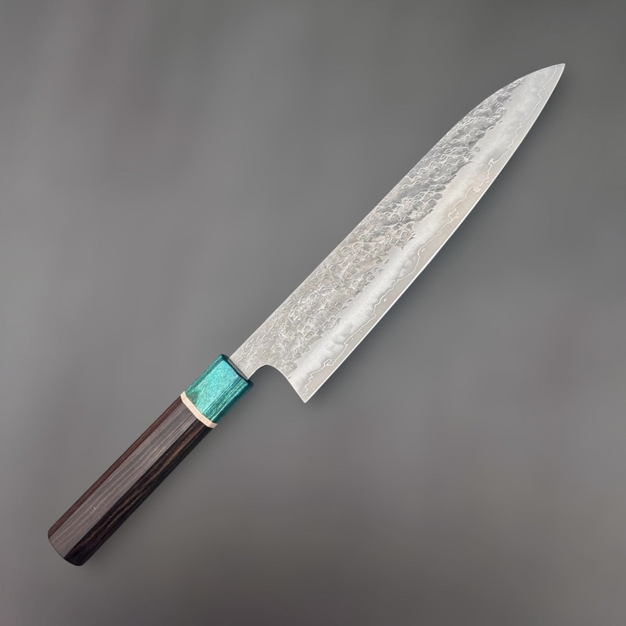 Makoto Kurosaki Samidorizuki SG-STRIX Gyuto 210 mm, angled full-length product view showing the hammered blade, wavy cladding line, and dark wa handle with turquoise ferrule.