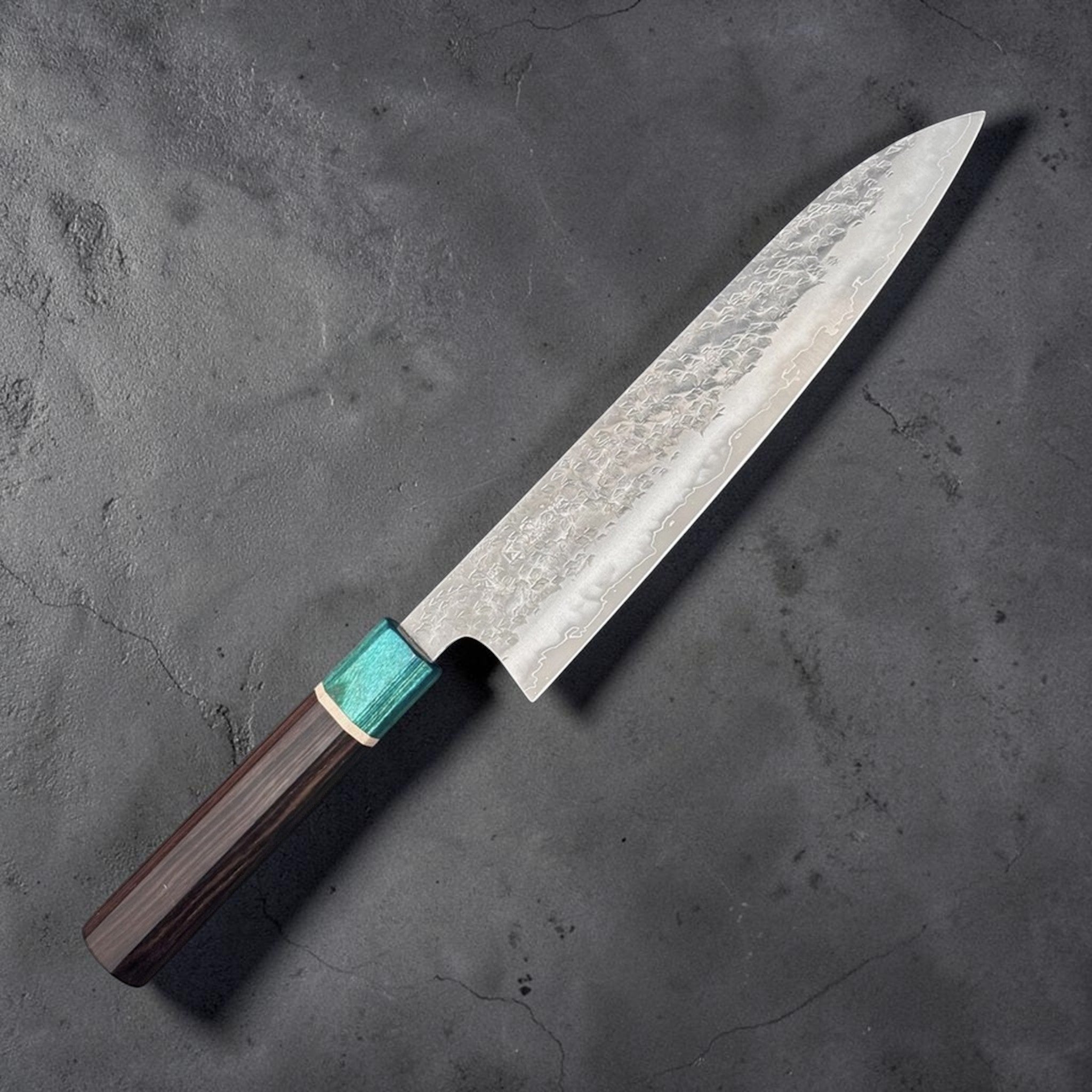 Makoto Kurosaki Samidorizuki SG-STRIX Gyuto 210 mm, angled full-length product view showing the hammered blade, wavy cladding line, and dark wa handle with turquoise ferrule.