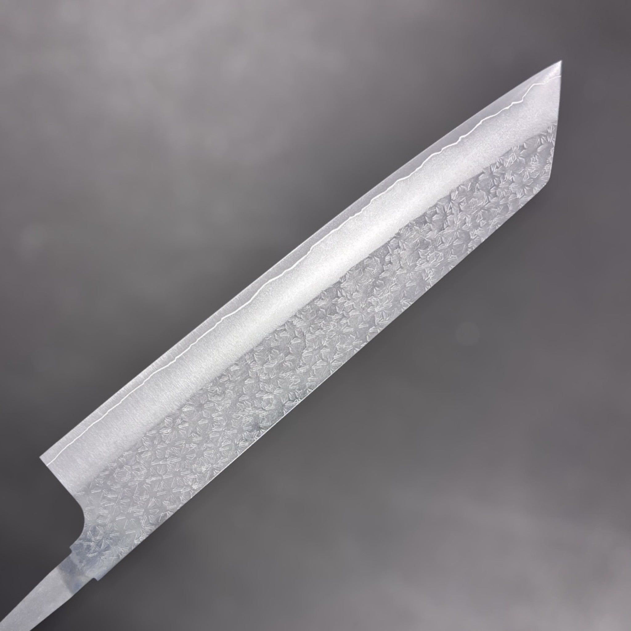 Makoto Kurosaki VG-XEOS Tsuchime Bunka 240 mm, alternate side close-up showing tsuchime cladding and crisp k-tip profile.