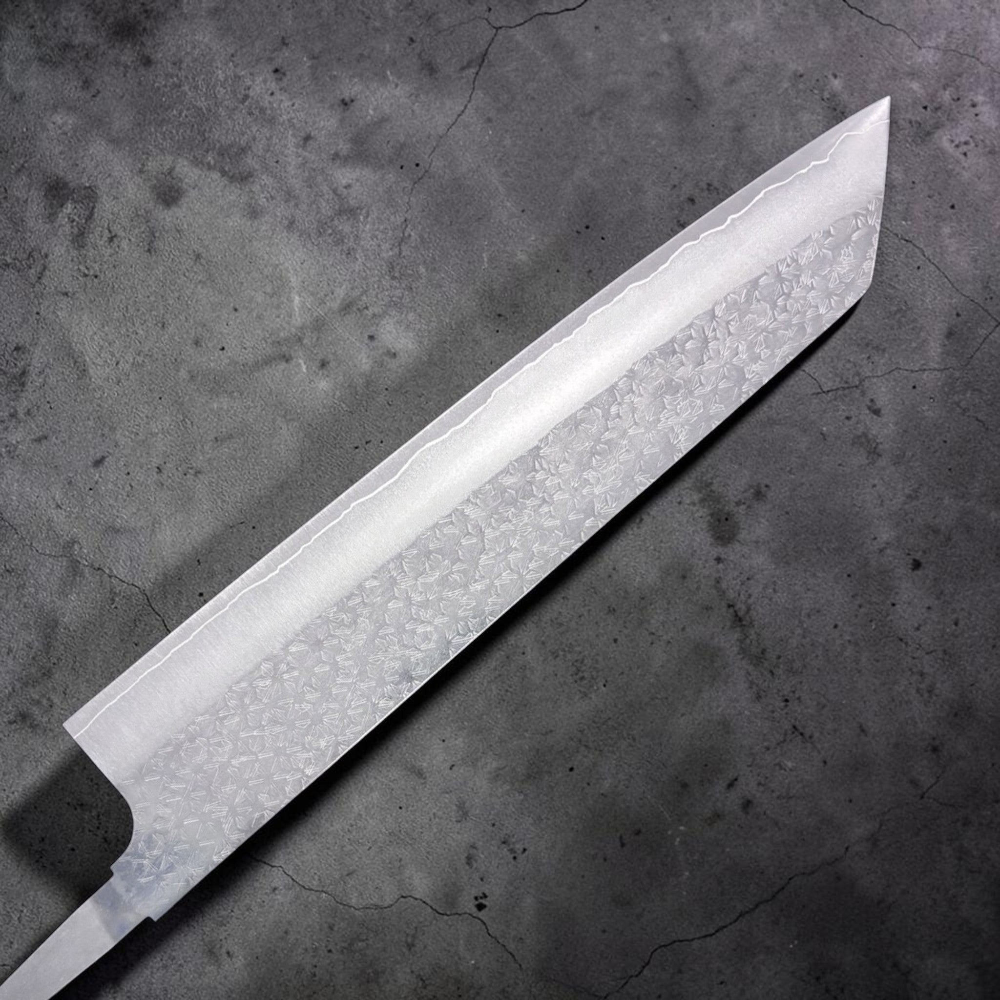 Makoto Kurosaki VG-XEOS Tsuchime Bunka 240 mm, alternate side close-up showing tsuchime cladding and crisp k-tip profile.