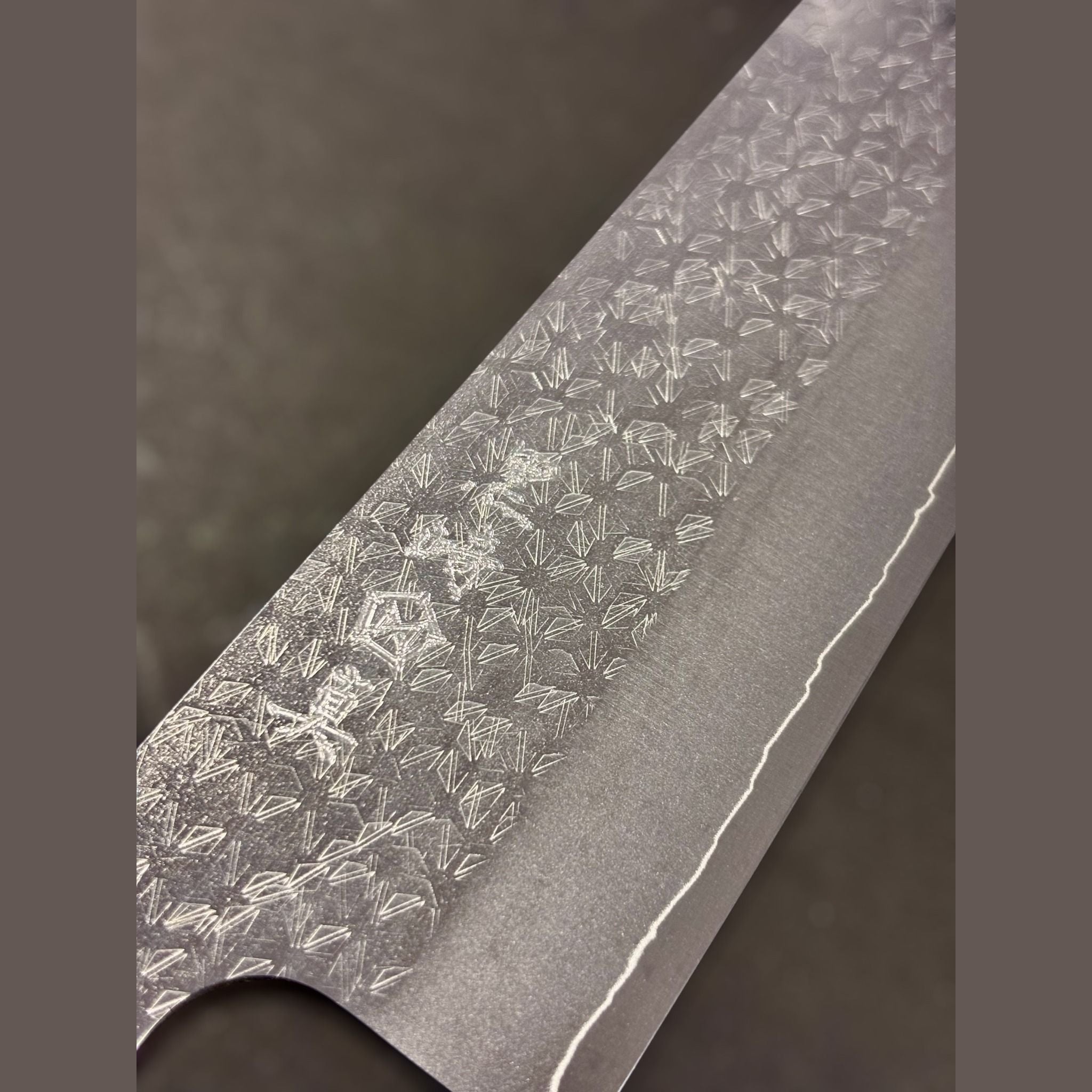 Makoto Kurosaki VG-XEOS Tsuchime Bunka 240 mm, close-up of maker’s kanji and detailed tsuchime cladding pattern on the blade face.