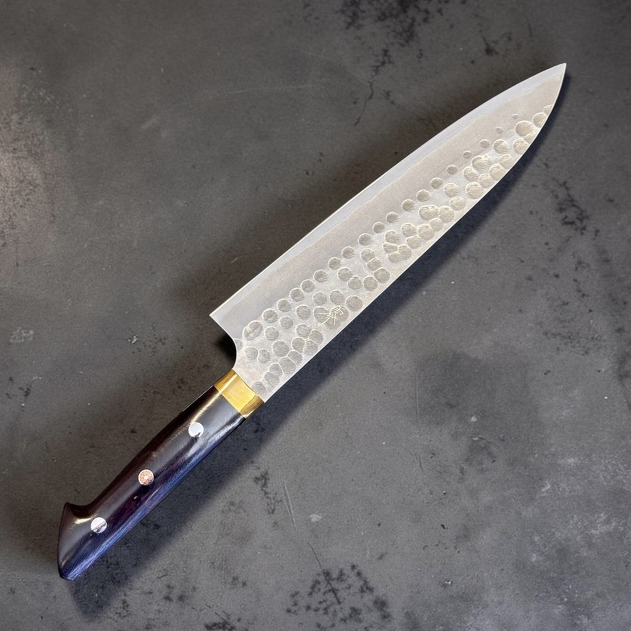 Masakage Zero Gyuto 210 mm, angled product view showing hammered blade and dark western handle.