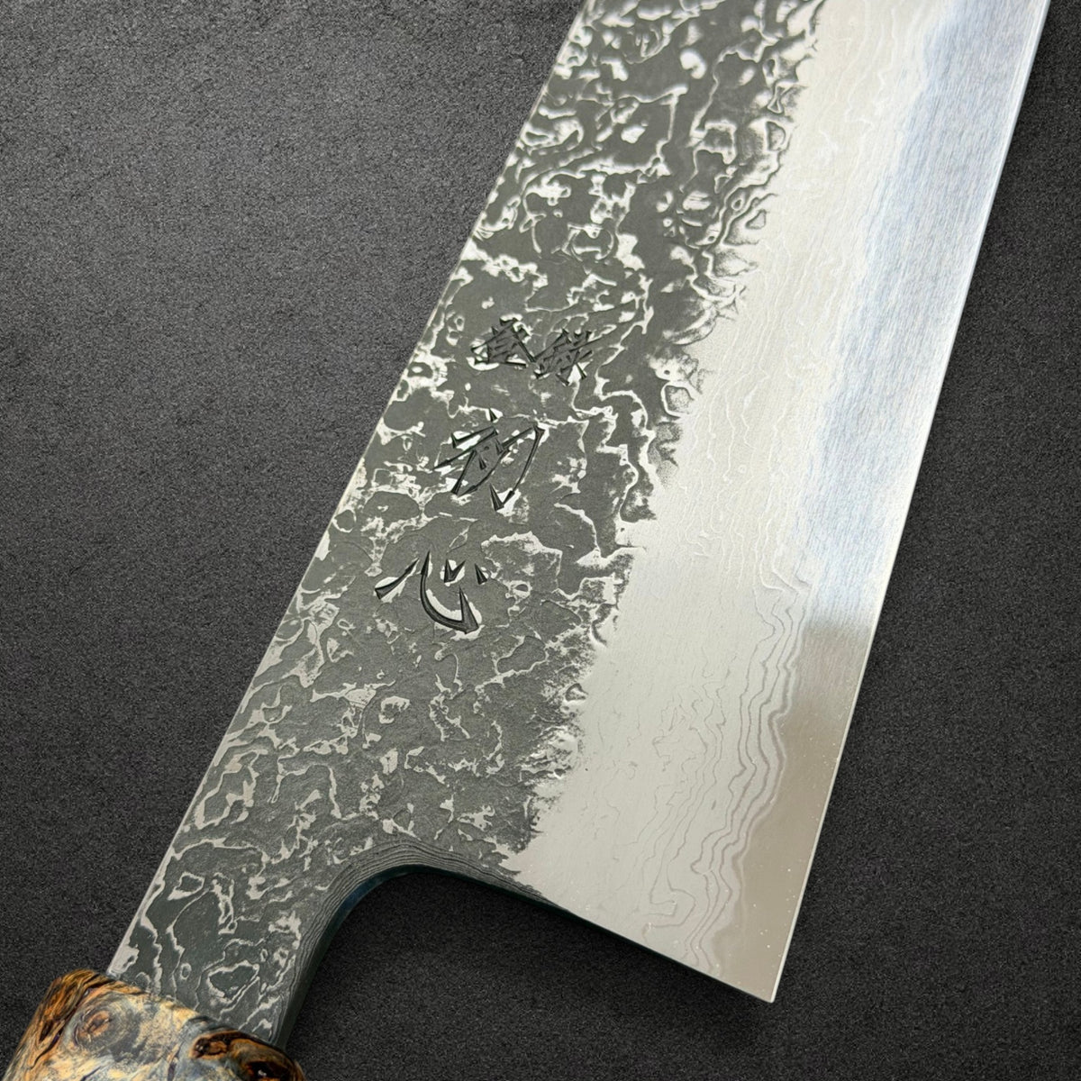 Close-up of Masuda engraving and dark Kurozome Damascus blade texture
